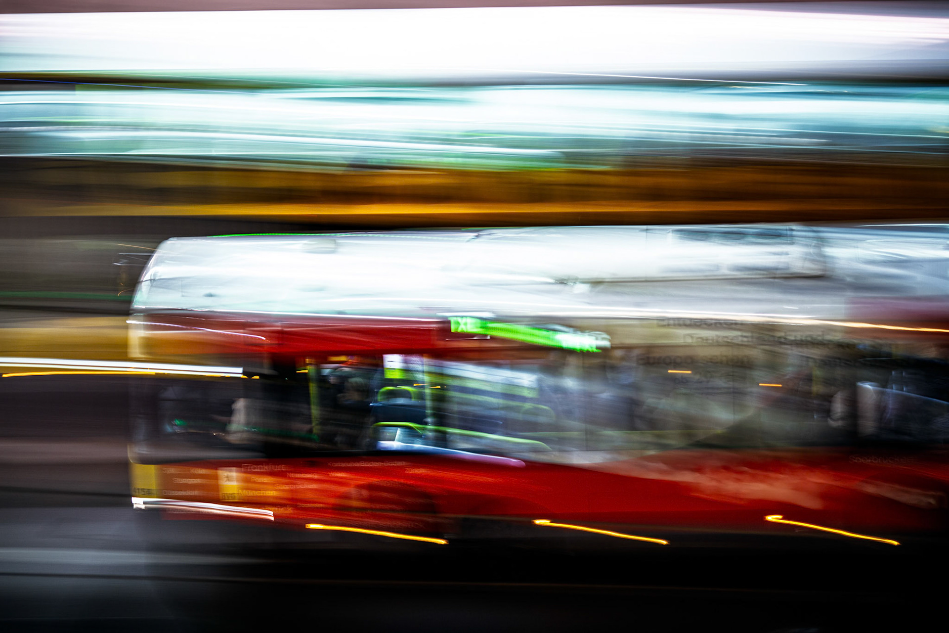 A vivid panning shot captures a bus moving swiftly through Berlin during the night, with city lights creating a vibrant atmosphere.