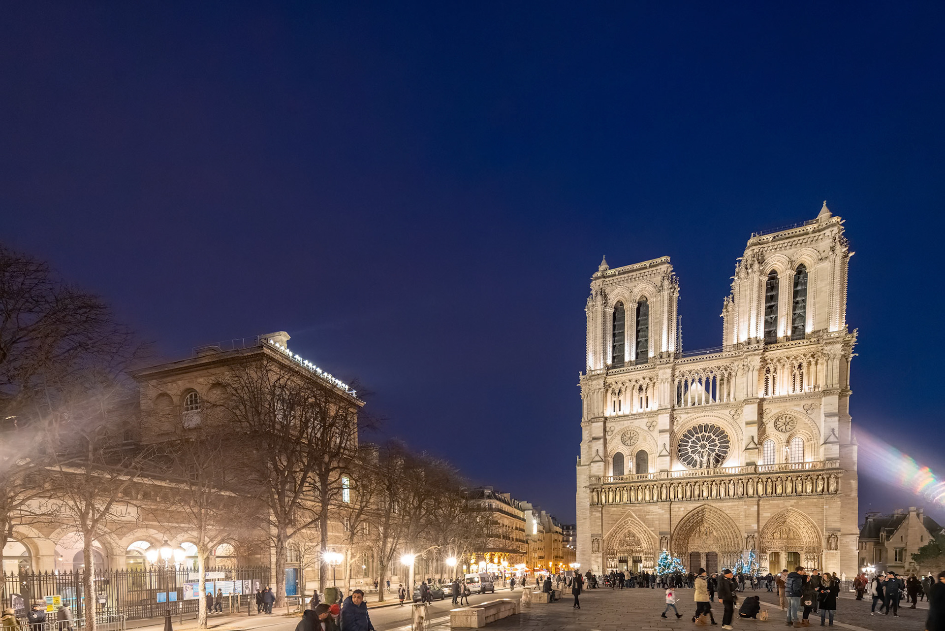 Crowd in front of iconic Notre Dame Cathedral during Christmas in Paris.