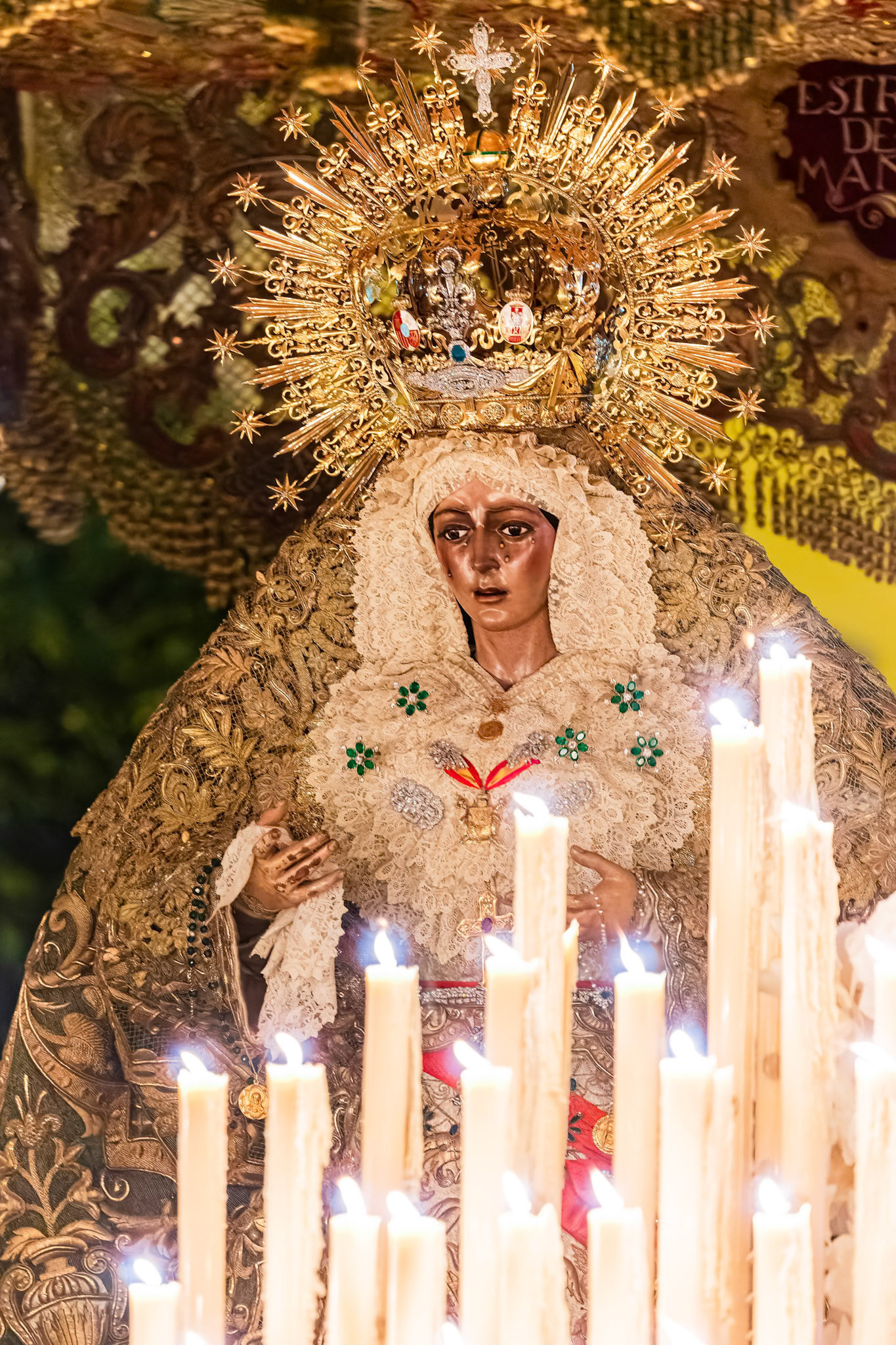 The Virgin Esperanza Macarena illuminated by the many candles of her processional canopy float during the solemn Madrugá procession in Seville's Holy Week.