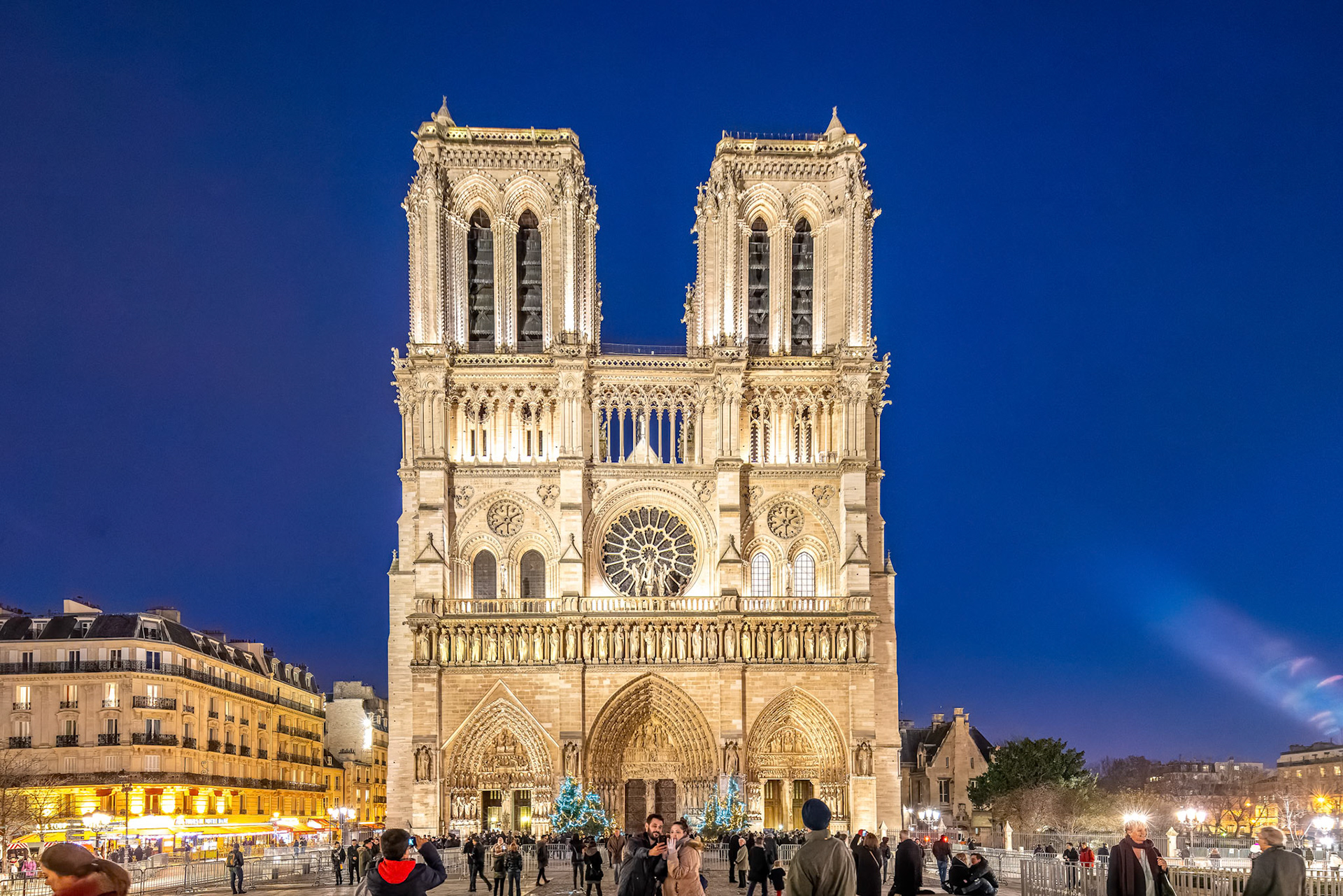 Crowd in front of iconic Notre Dame Cathedral during Christmas in Paris.