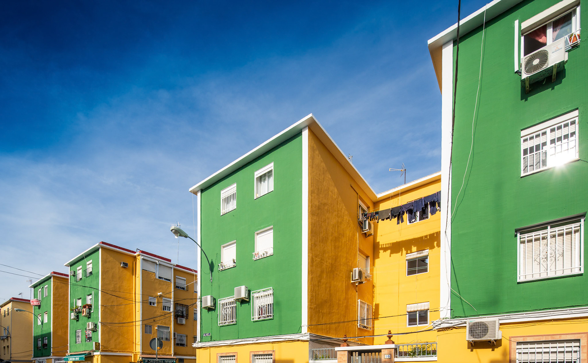 Colorful blocks of social housing in Seville, built from 1956 to 1961, showcase mid-century architectural ideals of urban planning.