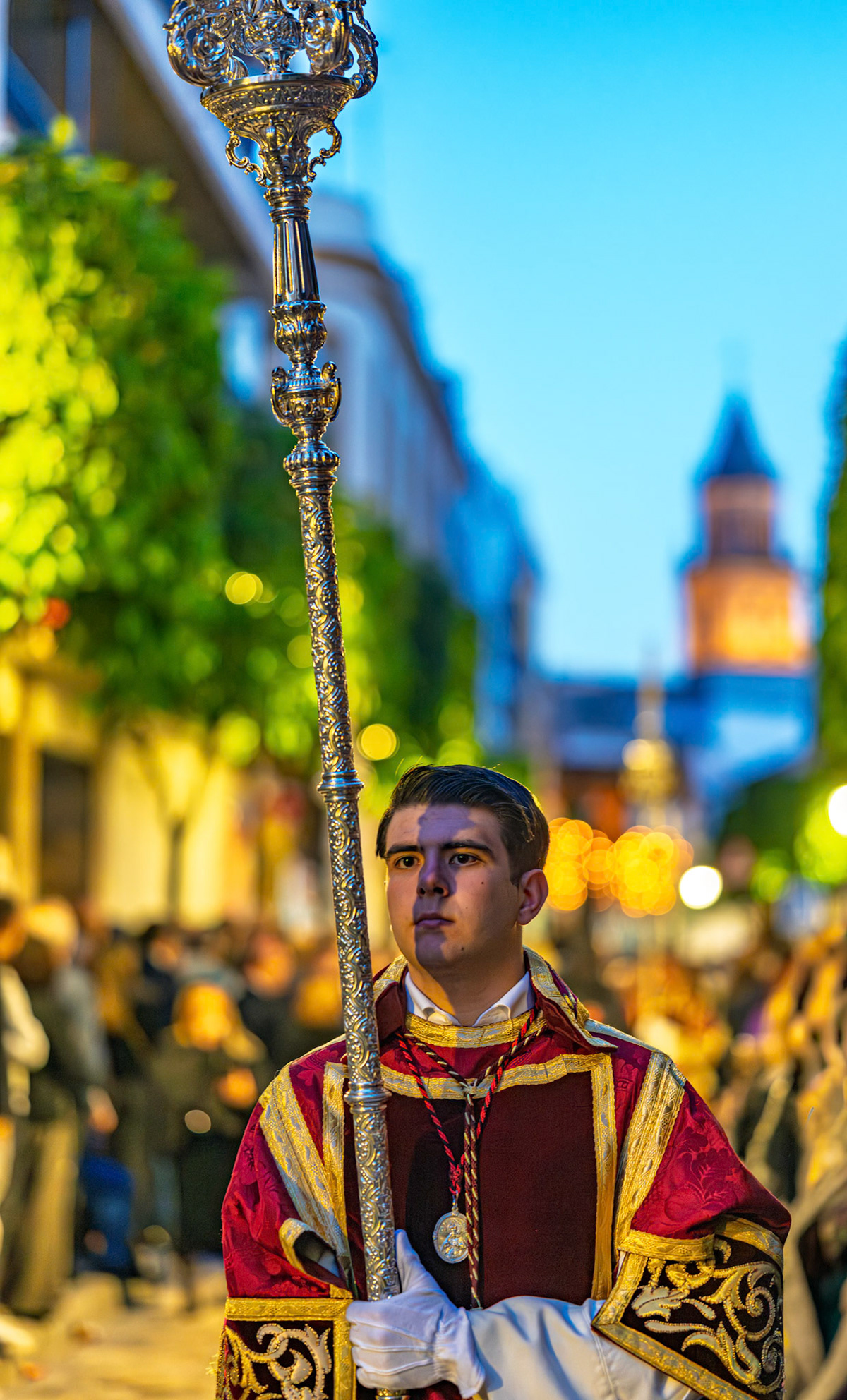 Seville, Spain: An acolyte carries an ornate processional candlestick for the Servitas Brotherhood's palio float, Holy Week.