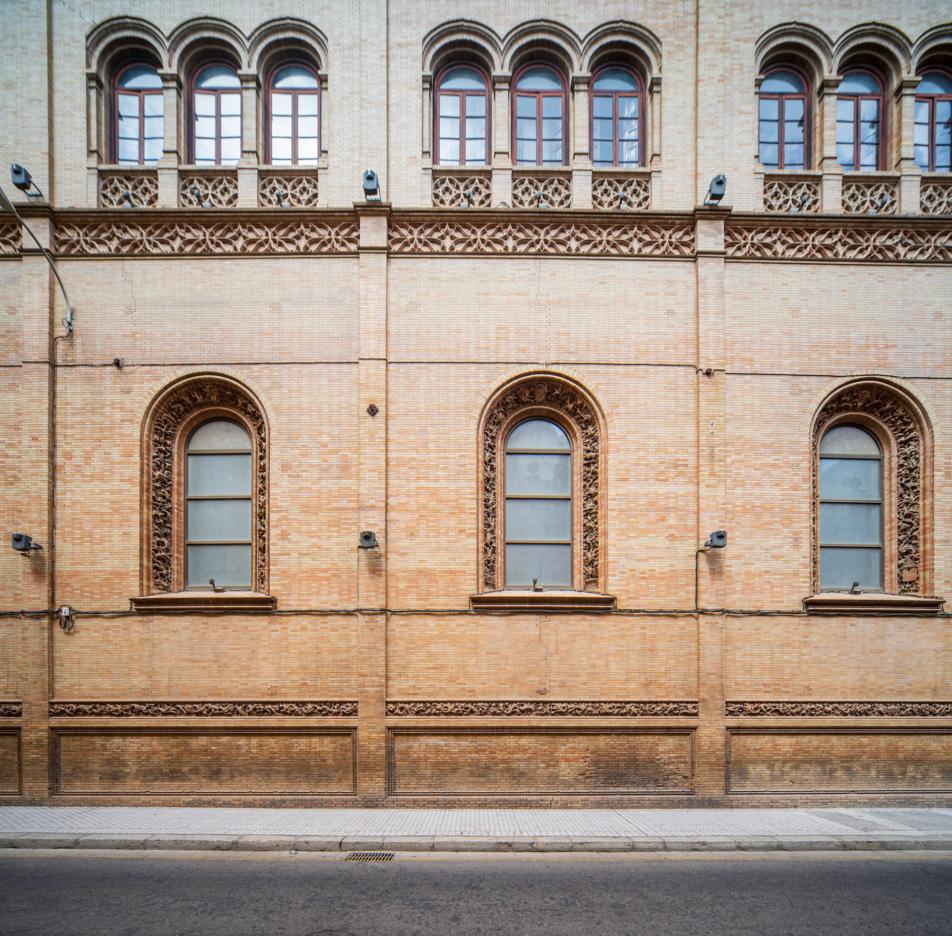 Facade of Capilla de los Luises with intricate windows, situated on Calle Trajano, Seville.