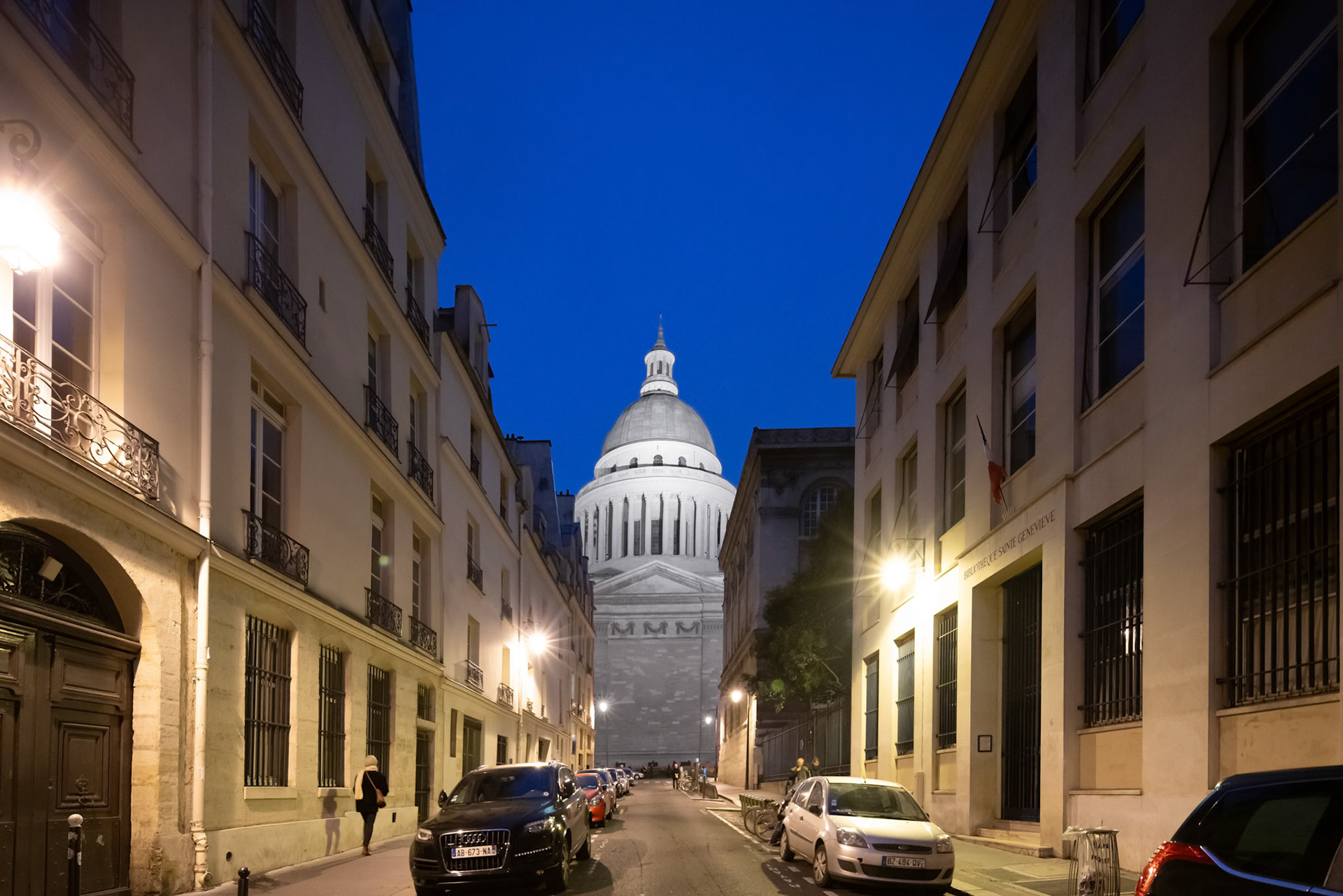 Dusk settles over Rue Valette with Le Panthéons dome illuminated in the background in Paris.