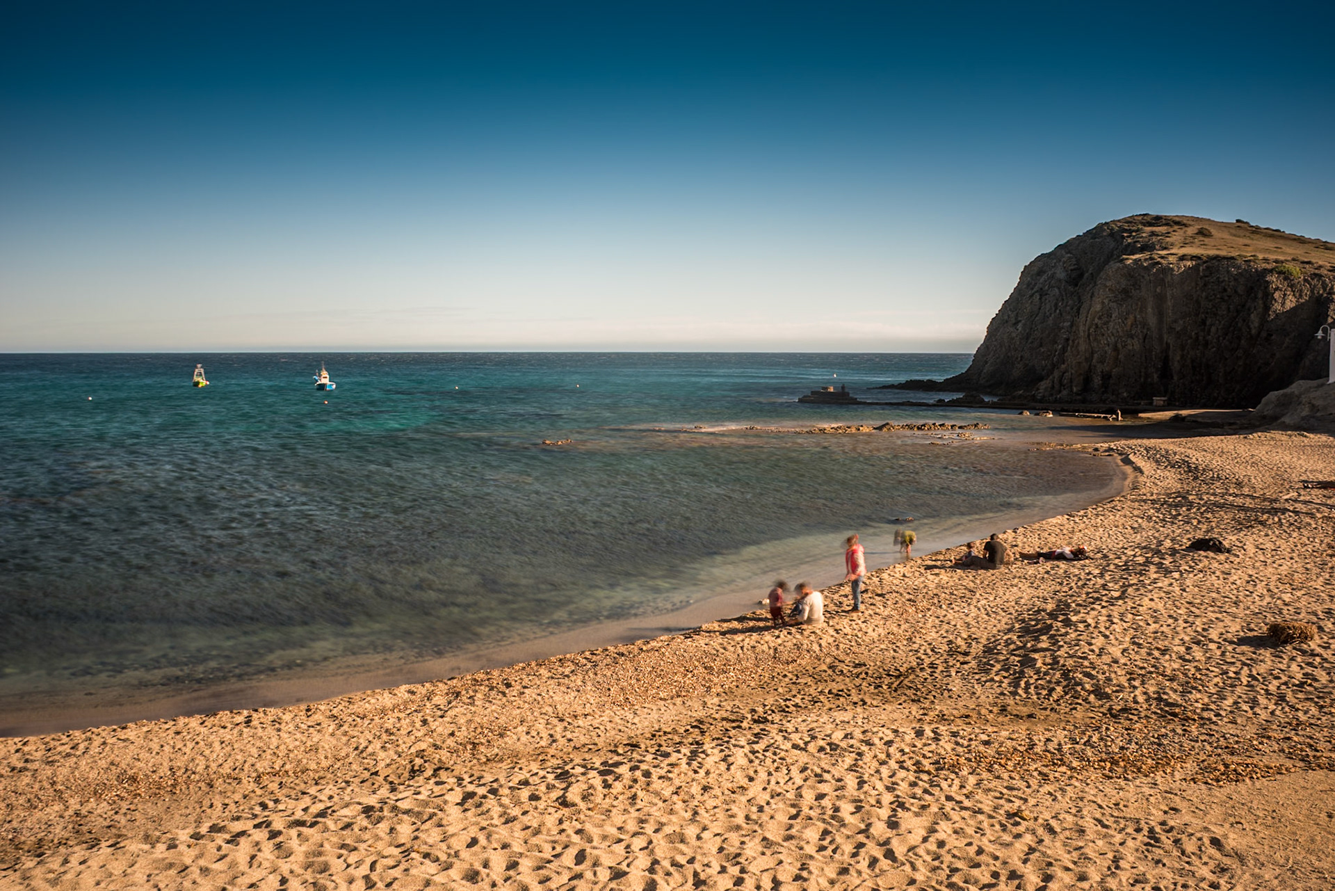 A family enjoys a winter day at a beach cove in Almeria, Andalucia, Spain.