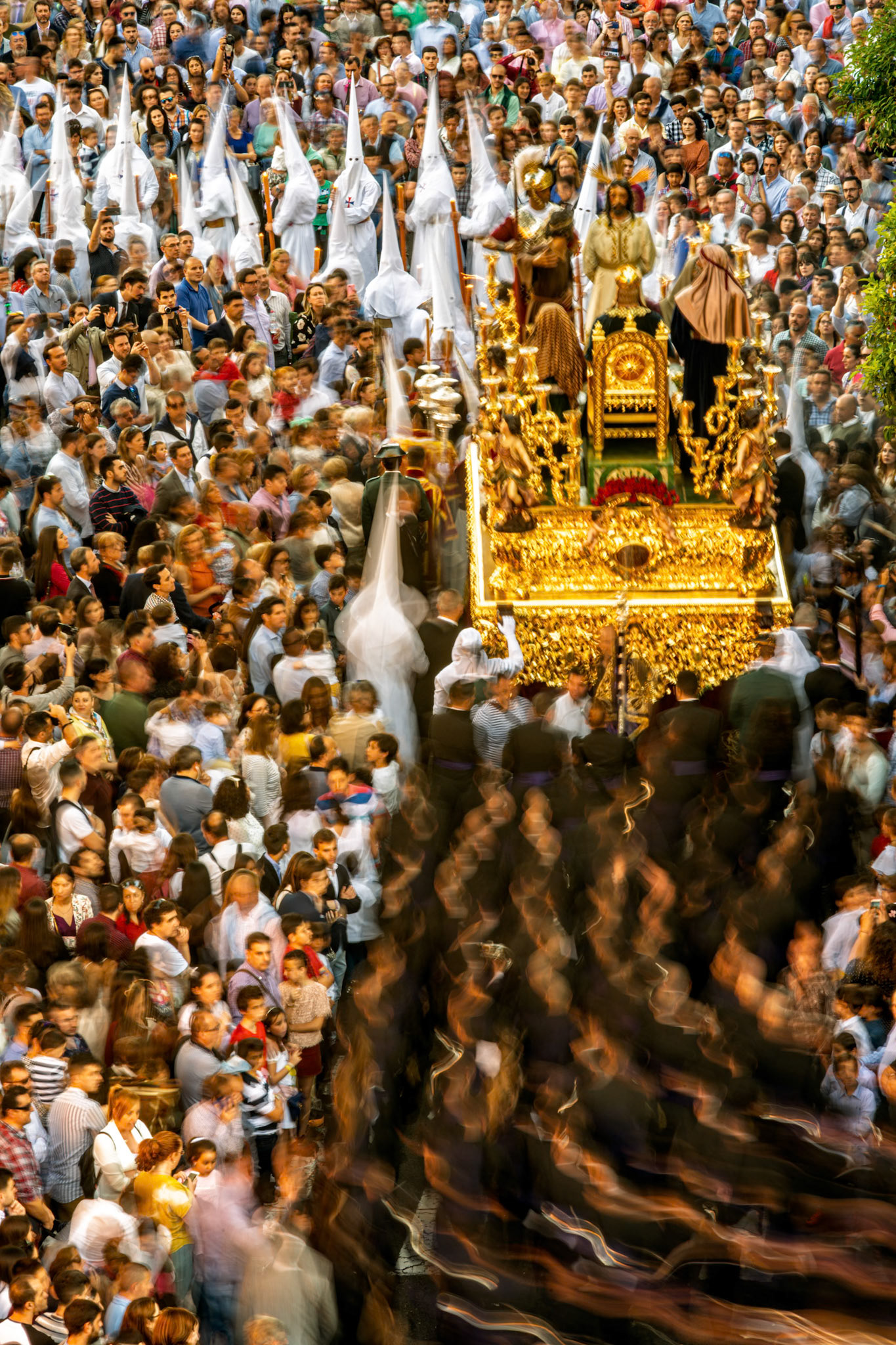 La Bofetá brotherhood's mystery float during Holy Week in Seville, Spain. Slow exposure captures the religious procession's vibrant atmosphere and dense crowd.