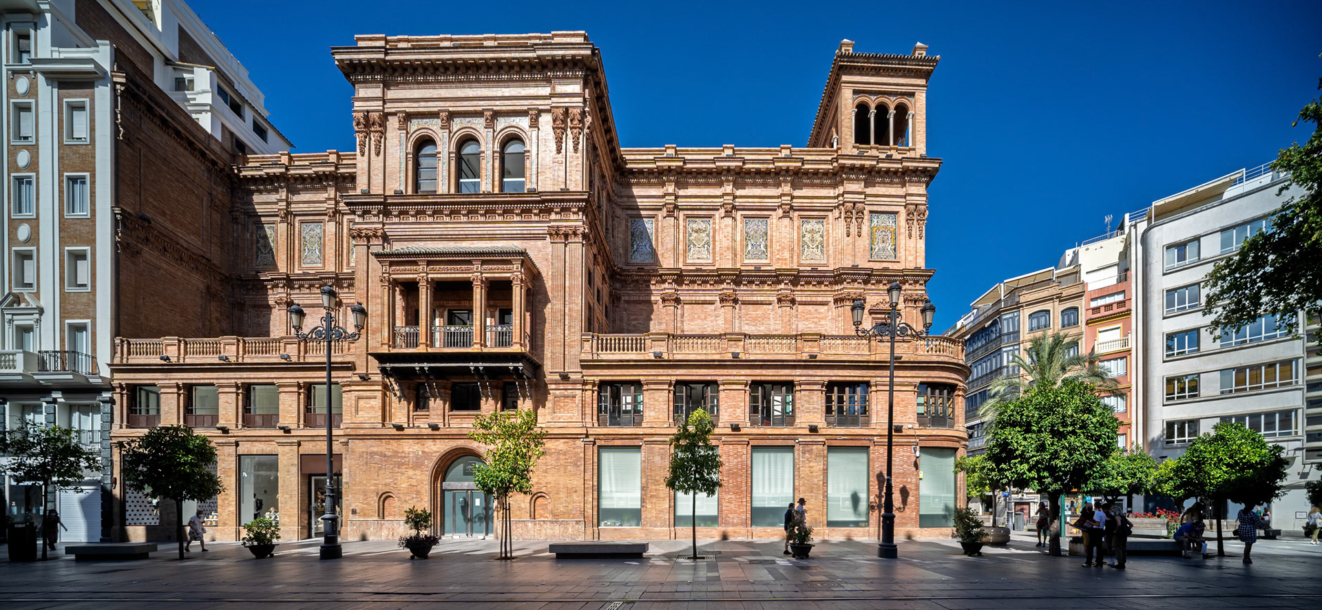 Coliseo building, Seville—regionalist landmark by José Espiau y Muñoz (1925–31), originally Teatro Coliseo España. Its ornate brick façade and tower anchor the Avenida near Plaza Rodríguez Jurado.