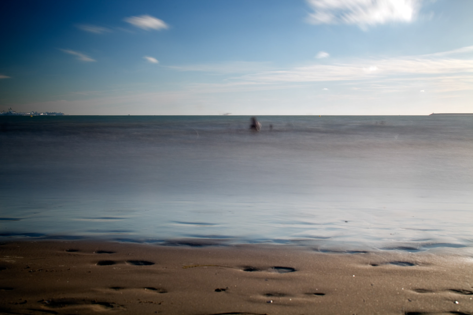People bathing on the sea, Valdelagrana  beach, El Puerto de Santa Maria, Spain. Daylight long exposure shot by the use of neutral density filters.