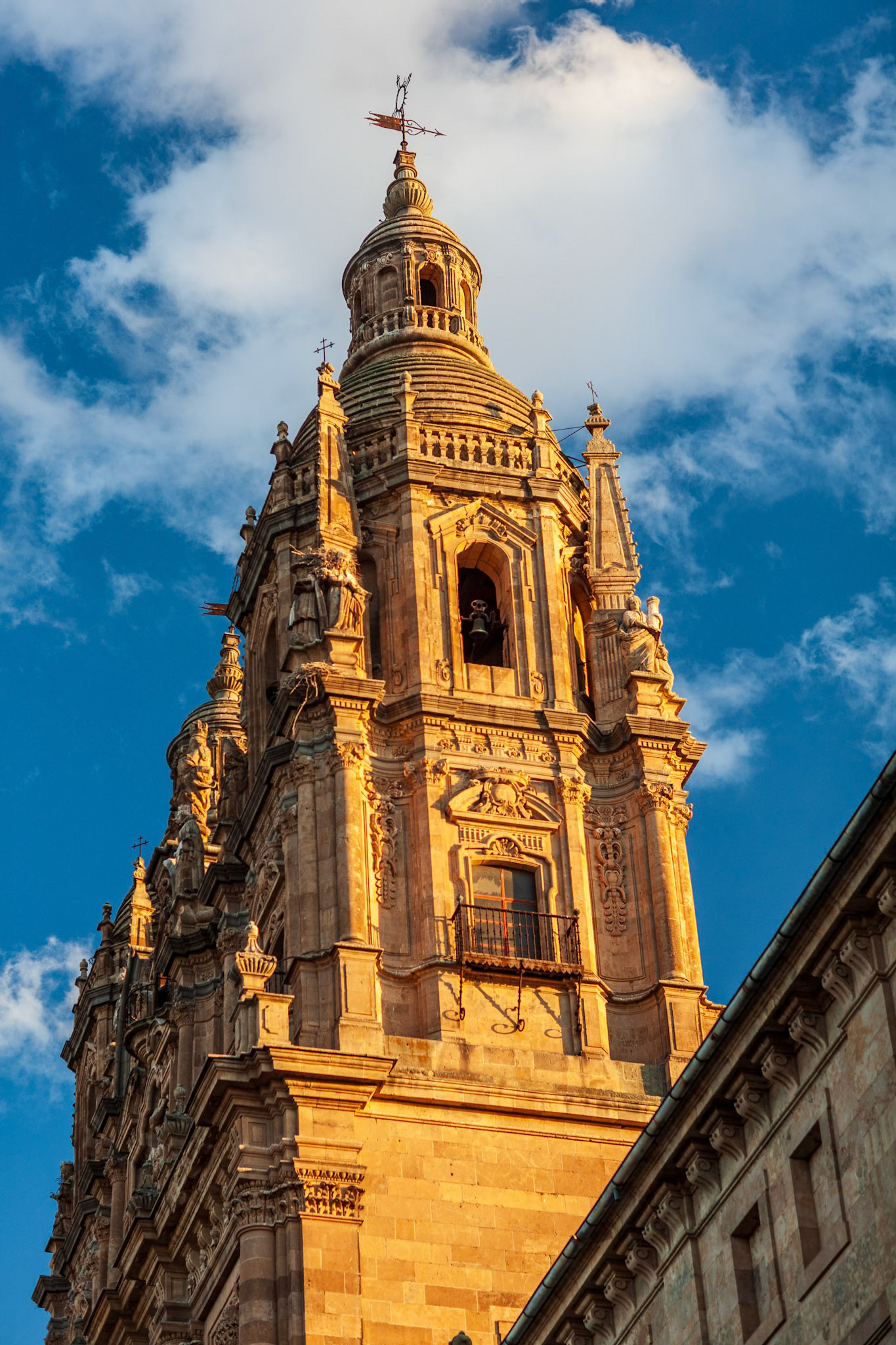 18th-century baroque tower of Clerecia church in Salamanca, Spain, under a vibrant sky.