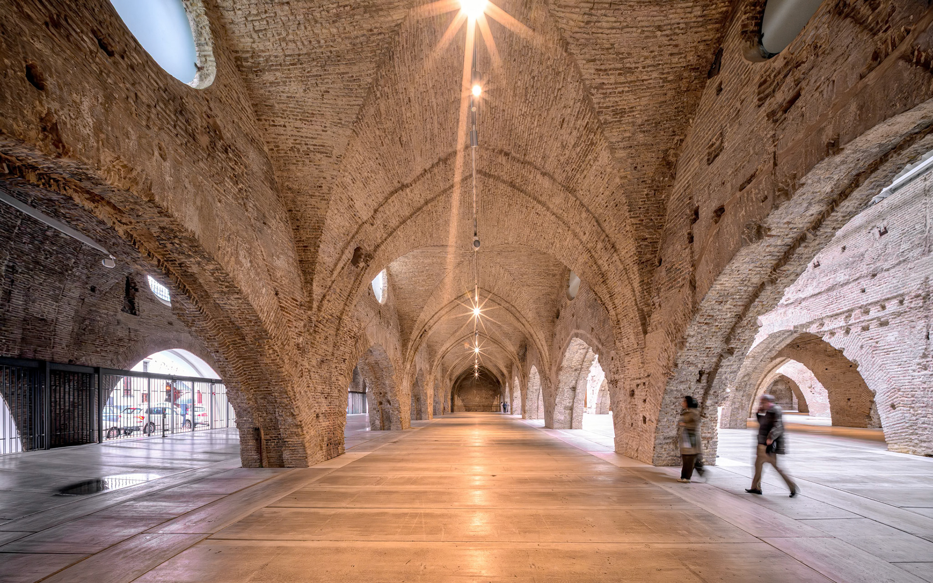 Atarazanas in Seville showcases restored 13th-century brick vaults, highlighting the beauty of arches and natural light.