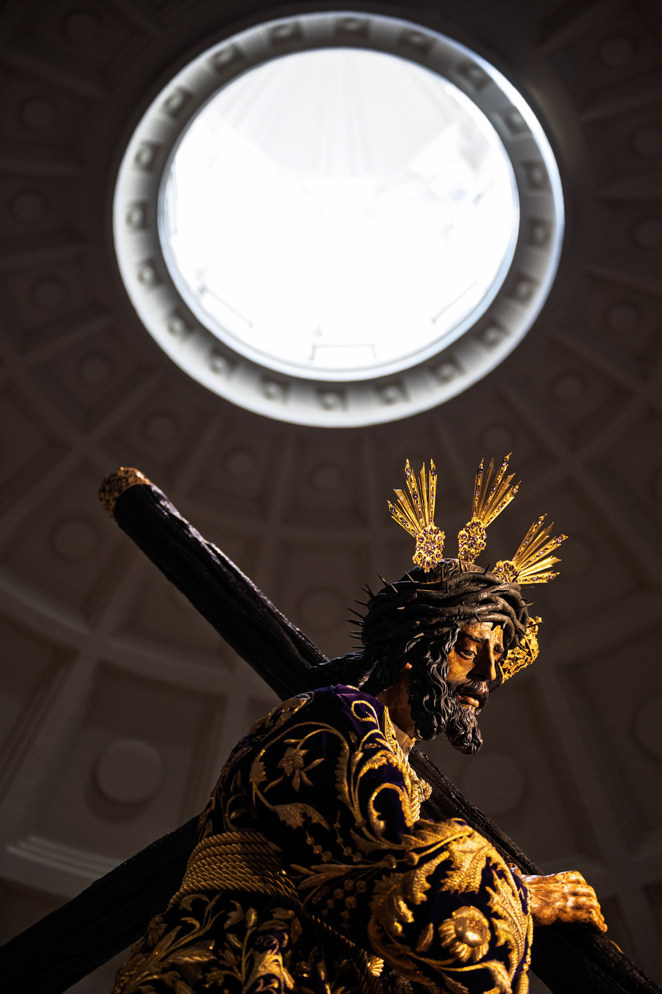 Lord of Gran Poder statue under basilica oculus, wearing the sumptuous 1881 'de los cardos' embroidered tunic. Holy Week, Seville, Andalusia, Spain.
