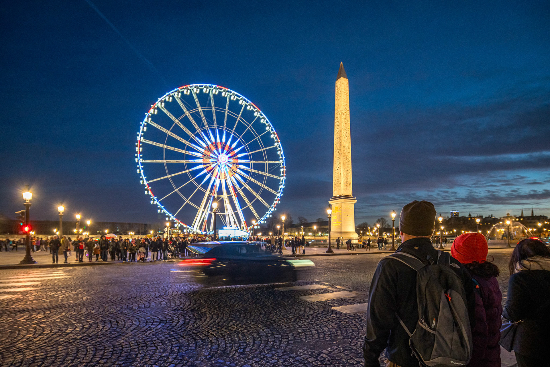 Ferris wheel lights up the evening by the famous obelisk.