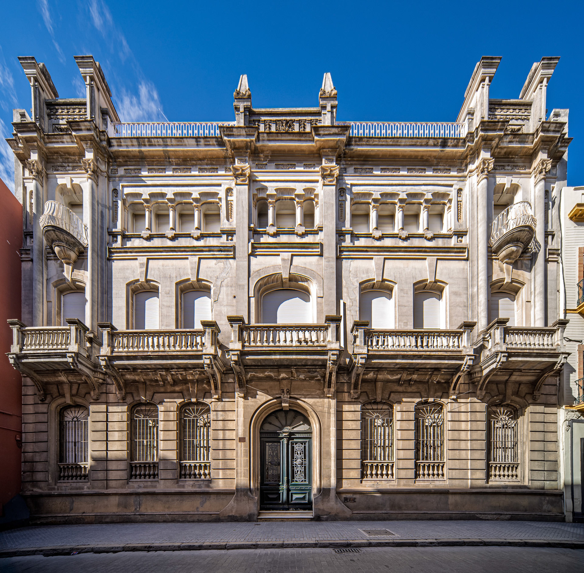 Palacio para la Marquesa  de las Cuevas del Becerro, Seville—eclectic façade from 1915 blends classical symmetry with Art Nouveau flourishes, framed by motion on cobbled streets
