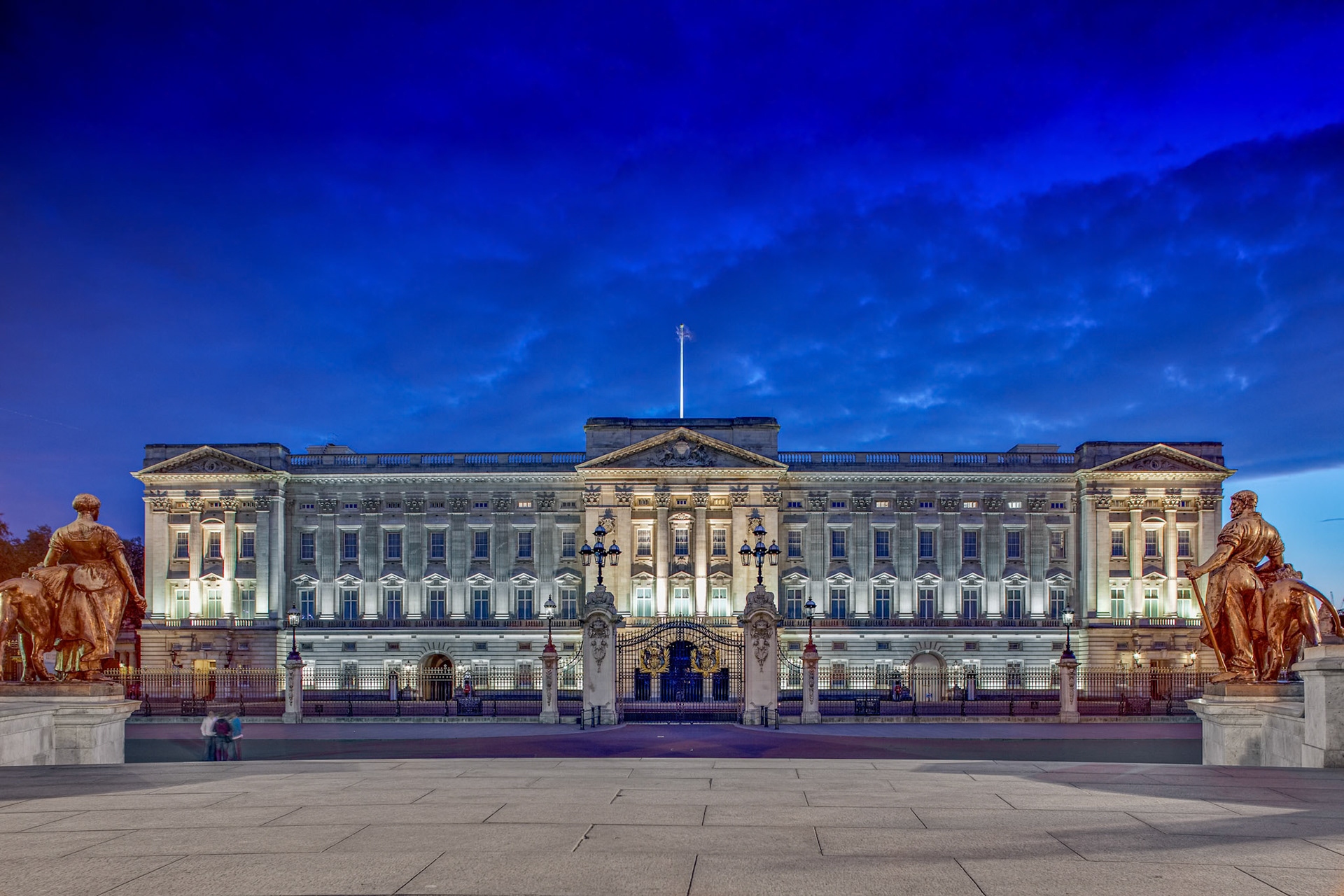Buckingham Palace illuminated against the twilight sky.