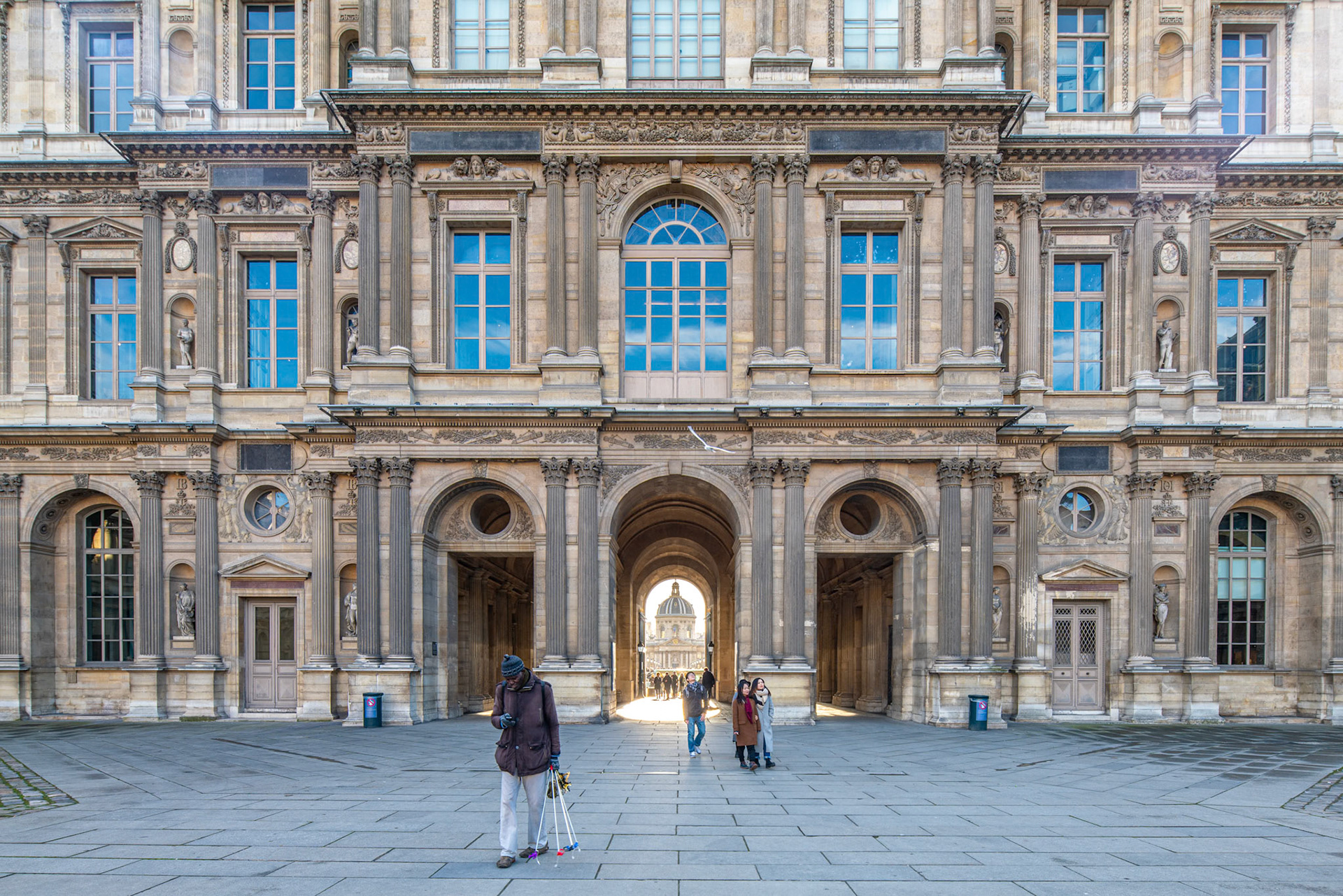 Visitors stroll through the Cour Carree at the Louvre in Paris.