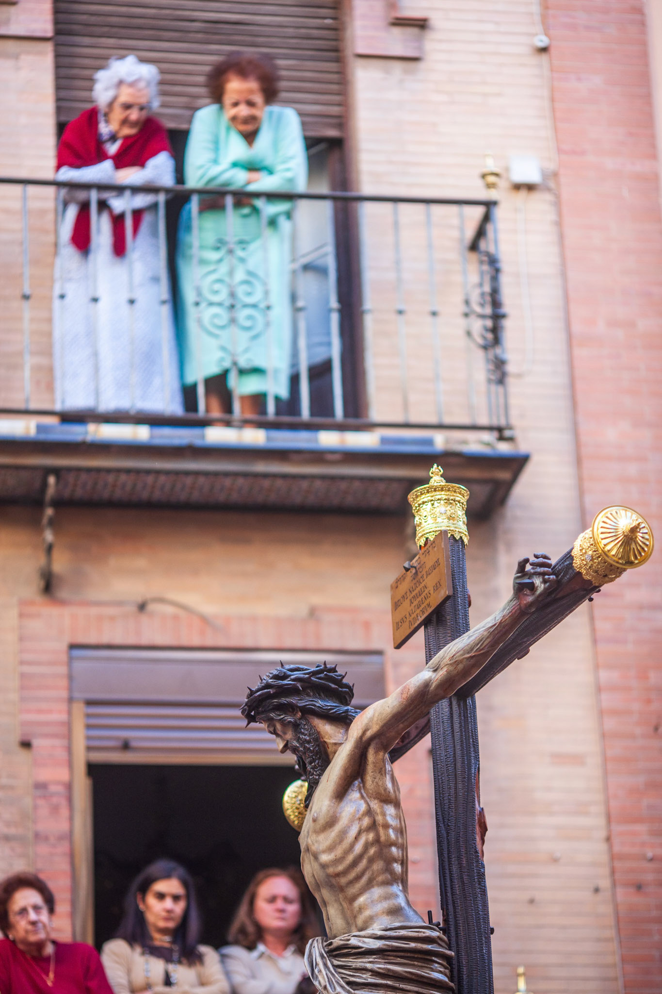 Seville, Spain, Apr 2 2010, Women on their balcony admire the Cristo del Buen Fin during Seville's Holy Week, celebrating a cherished family tradition.