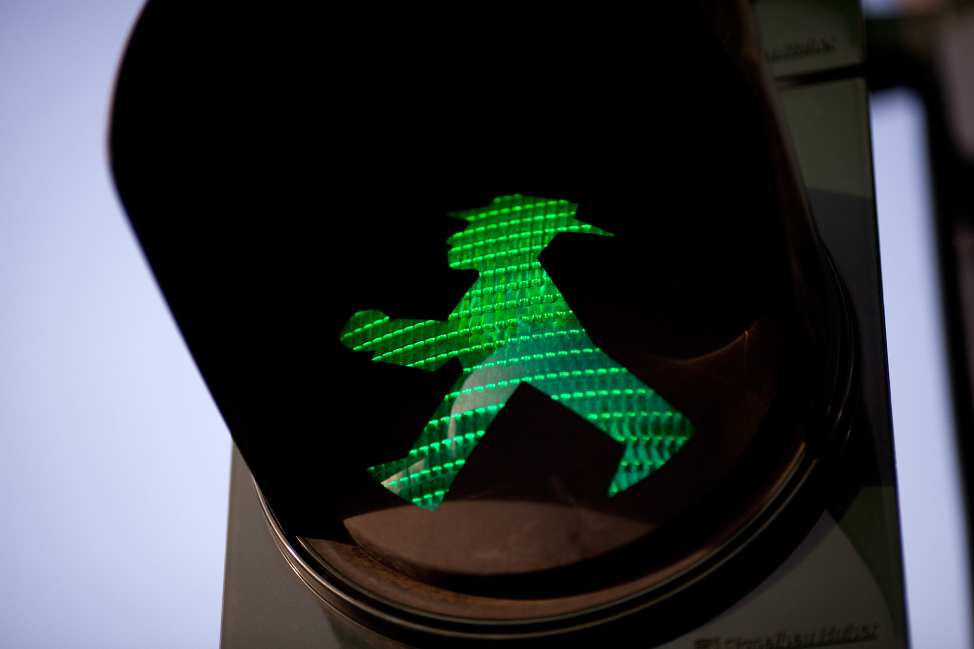 A green Ampelmännchen pedestrian signal shines in East Berlin, inviting walkers to cross the street safely.