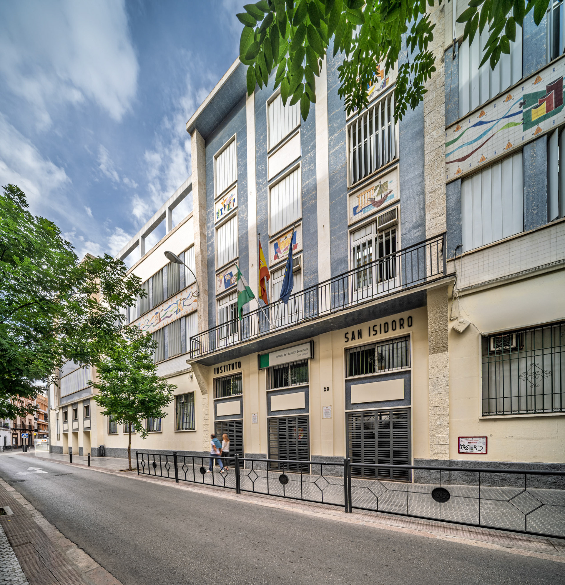 Instituto San Isidoro, founded in 1845, showcases its rationalist architecture in Seville, highlighting vertical windows and ceramic friezes.