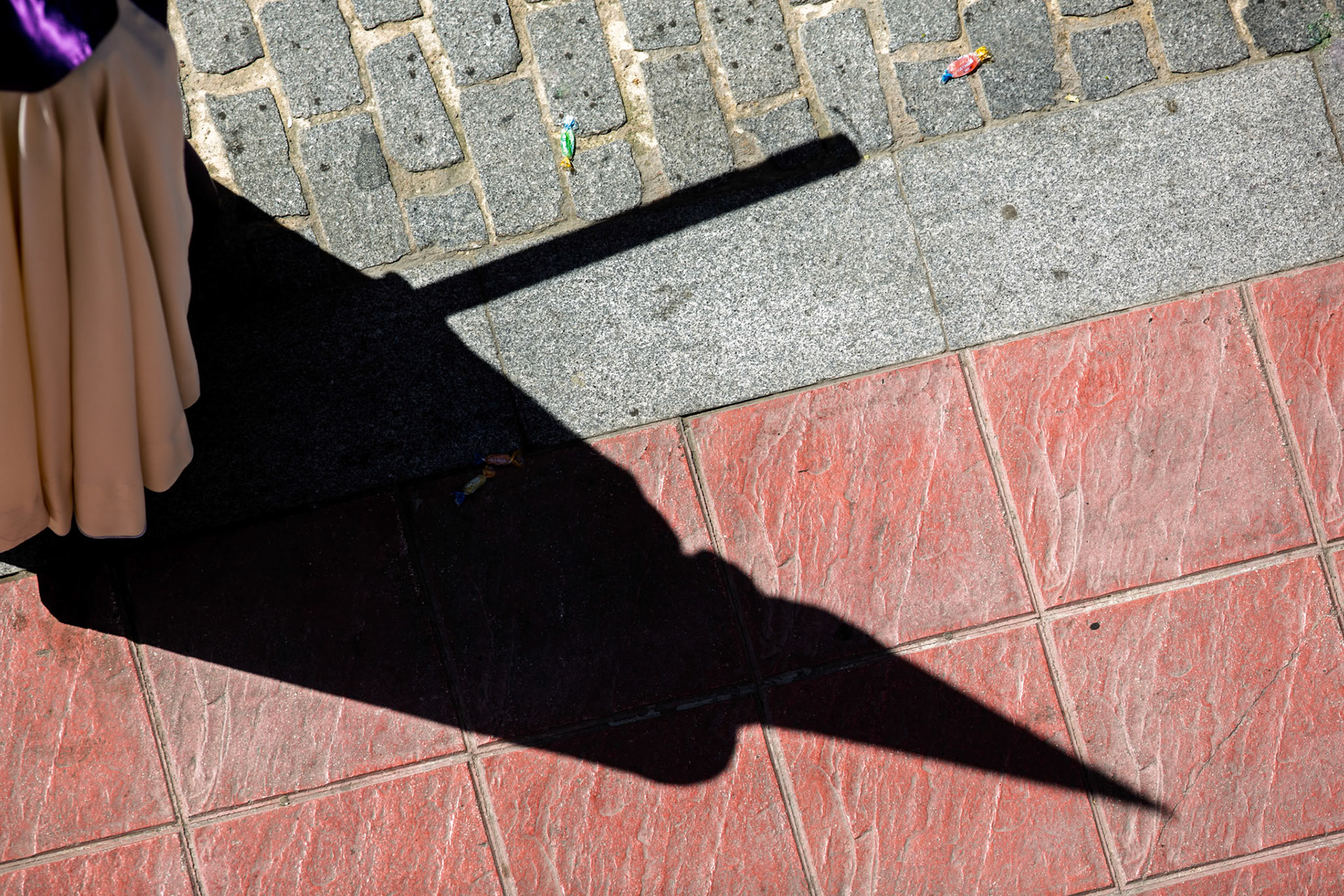 A penitent's shadow with a pointed hood during a Holy Week procession in Spain.