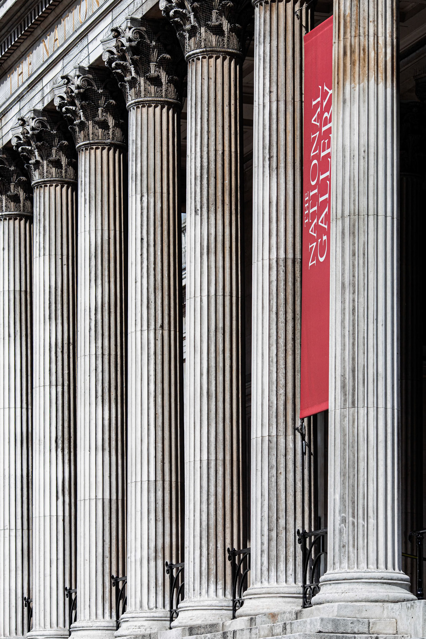 Columns stand tall at the National Gallery, showcasing classic architecture in London. Visitors can explore art and history near this famous landmark.