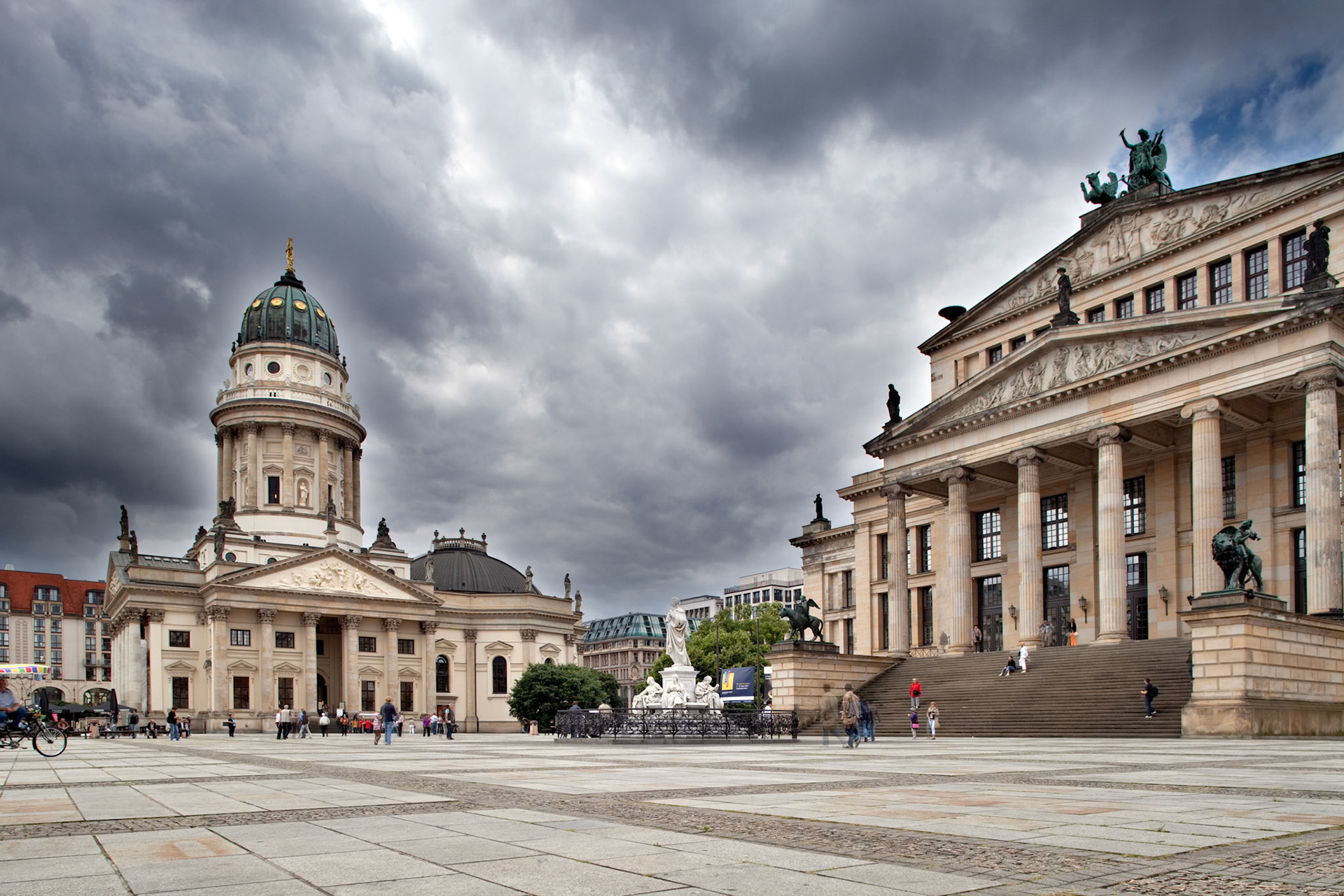 Explore the stunning architecture of Deutsche Dom and Konzerthaus in Gendarmenmarkt, Berlin, as clouds loom overhead.