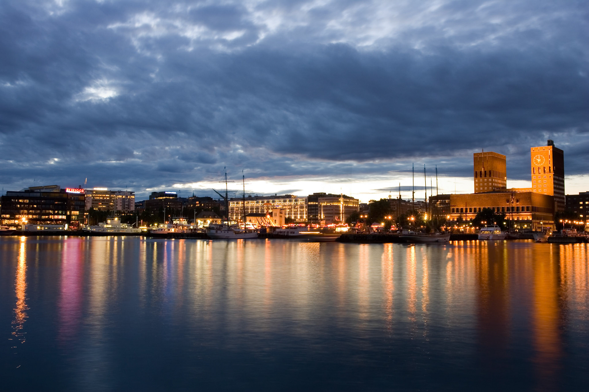 Moody, atmospheric image of downtown Oslo reflected on the harbor water. Long exposure.
