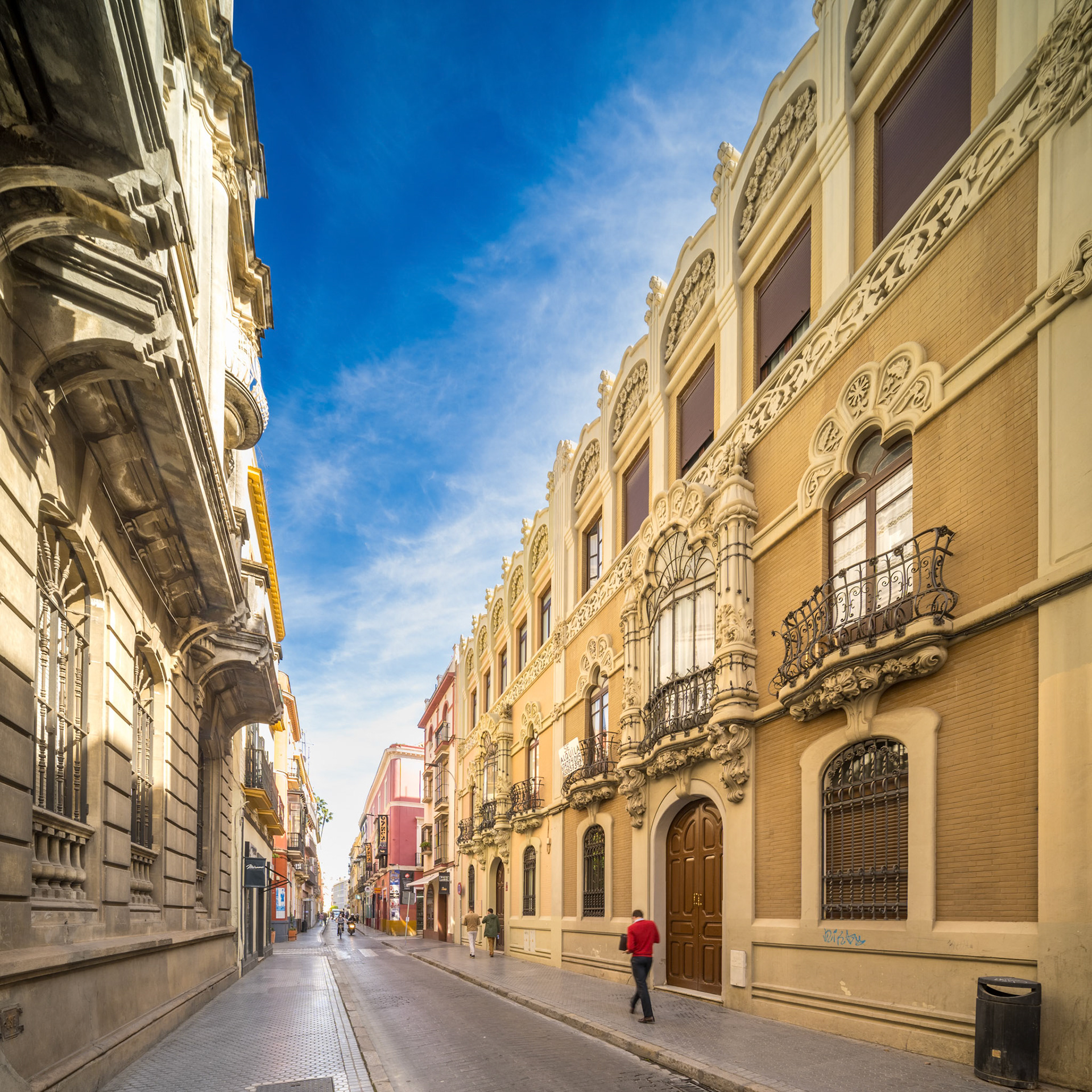 Charming street view of Calle Alfonso XII in Seville featuring the modernist Laureano Montoto building designed by Aníbal González in 1905.