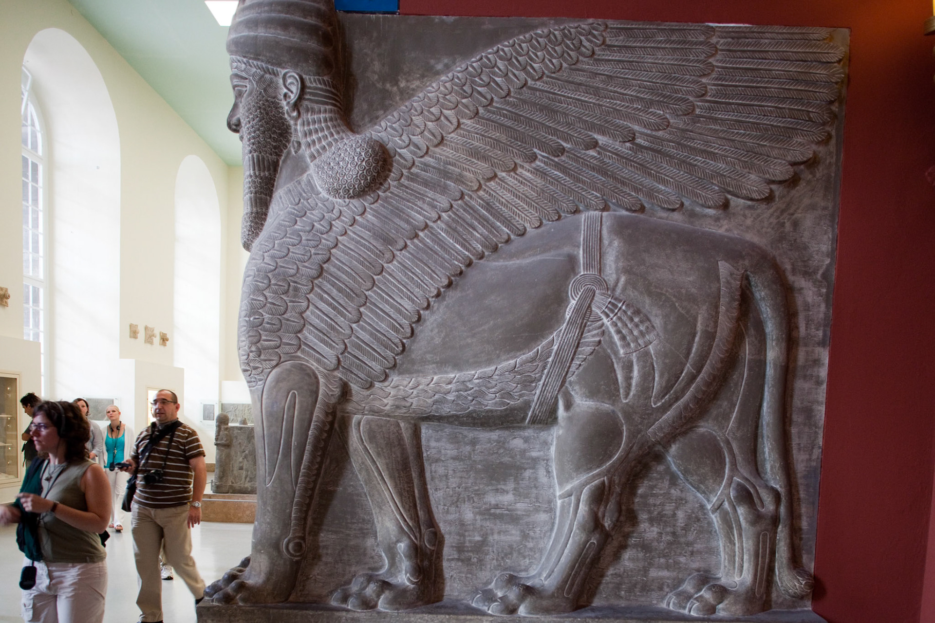 Berlin, Germany, July 24 2009, A massive Assyrian winged lion figure with a human head stands in the Pergamon Museum, attracting visitors in Berlin, Germany.