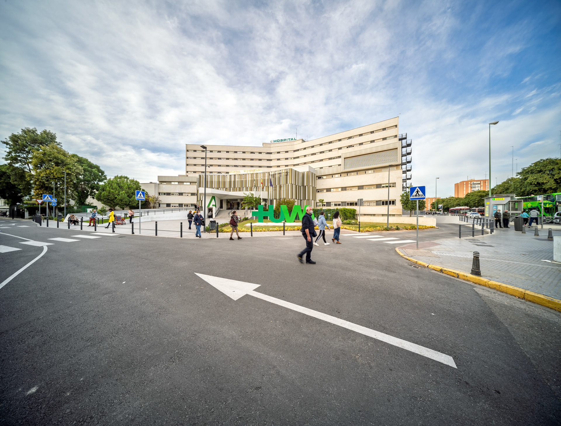 Hospital Universitario Virgen Macarena in Seville features a modern complex and bustling pedestrian activity, emphasizing its local healthcare role.