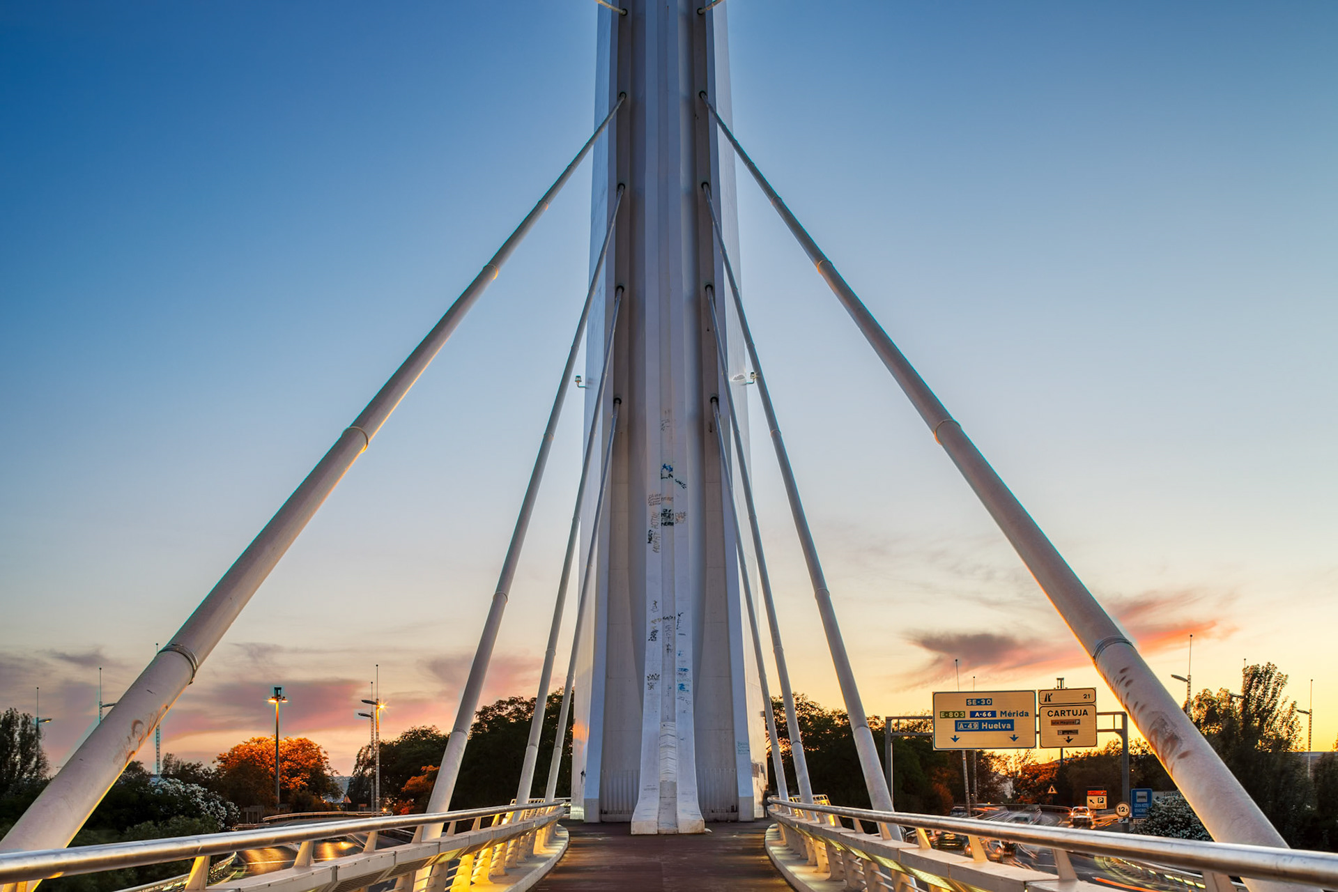 The towering white concrete base of the Alamillo Bridge stands majestically at twilight, capturing the last light against its angular shape.