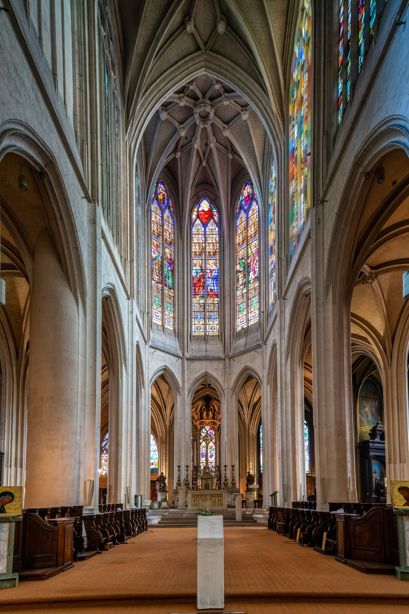 The grandiose nave of Saint-Gervais-Saint-Protais Church, showcasing stunning stained glass windows.