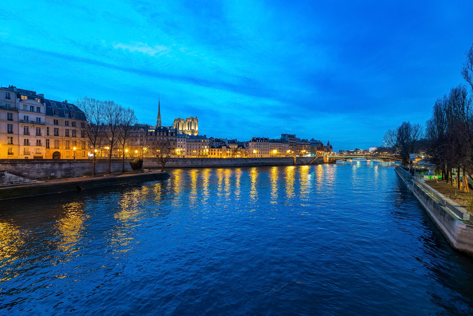 Evening view of the Seine River and Île de la Cité with Notre Dame Cathedral in Paris.