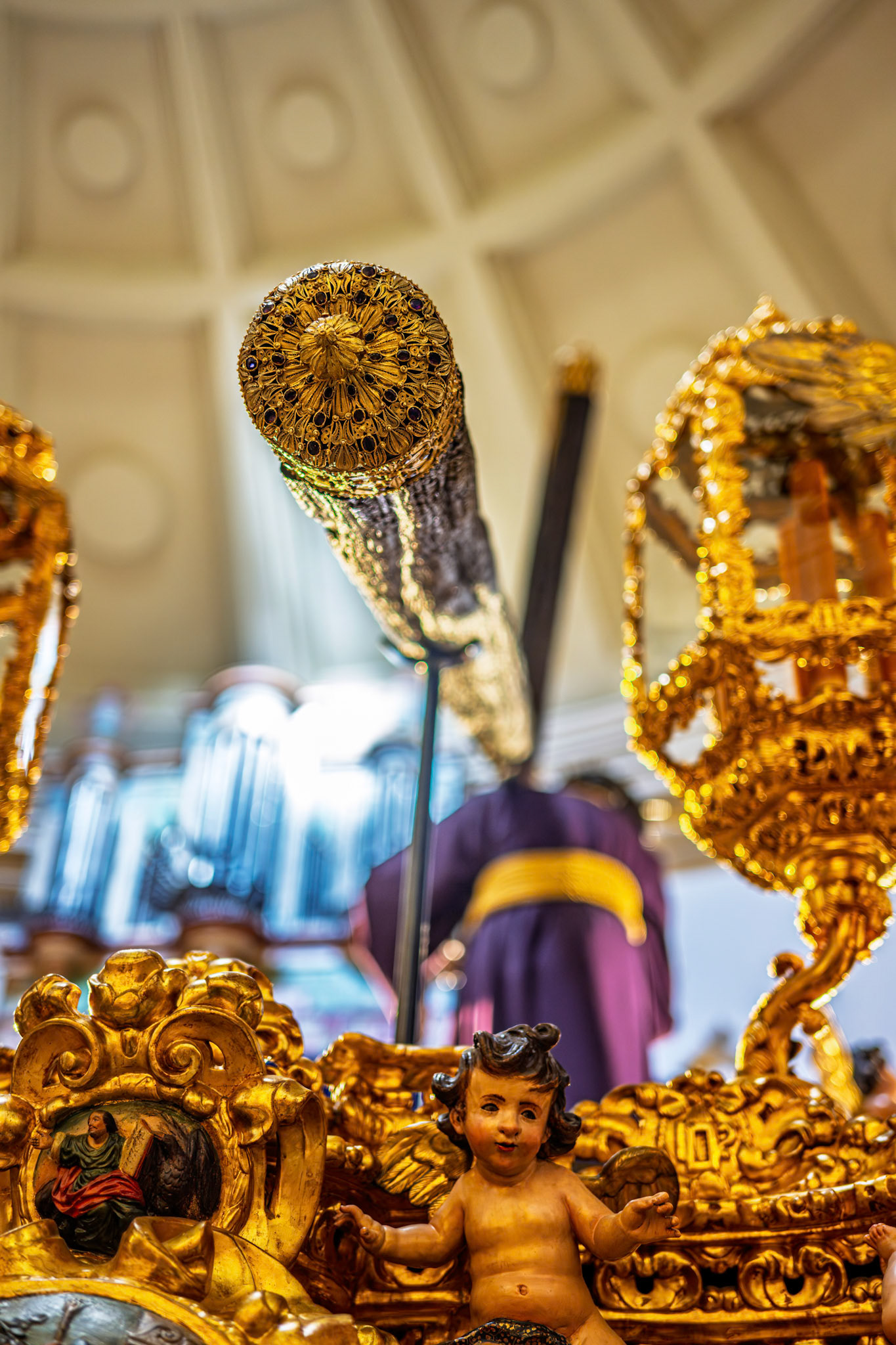 Rear part of the Gran Poder Holy Week float, Seville, Spain, with selective focus on the rich gold decoration at the base of the cross.