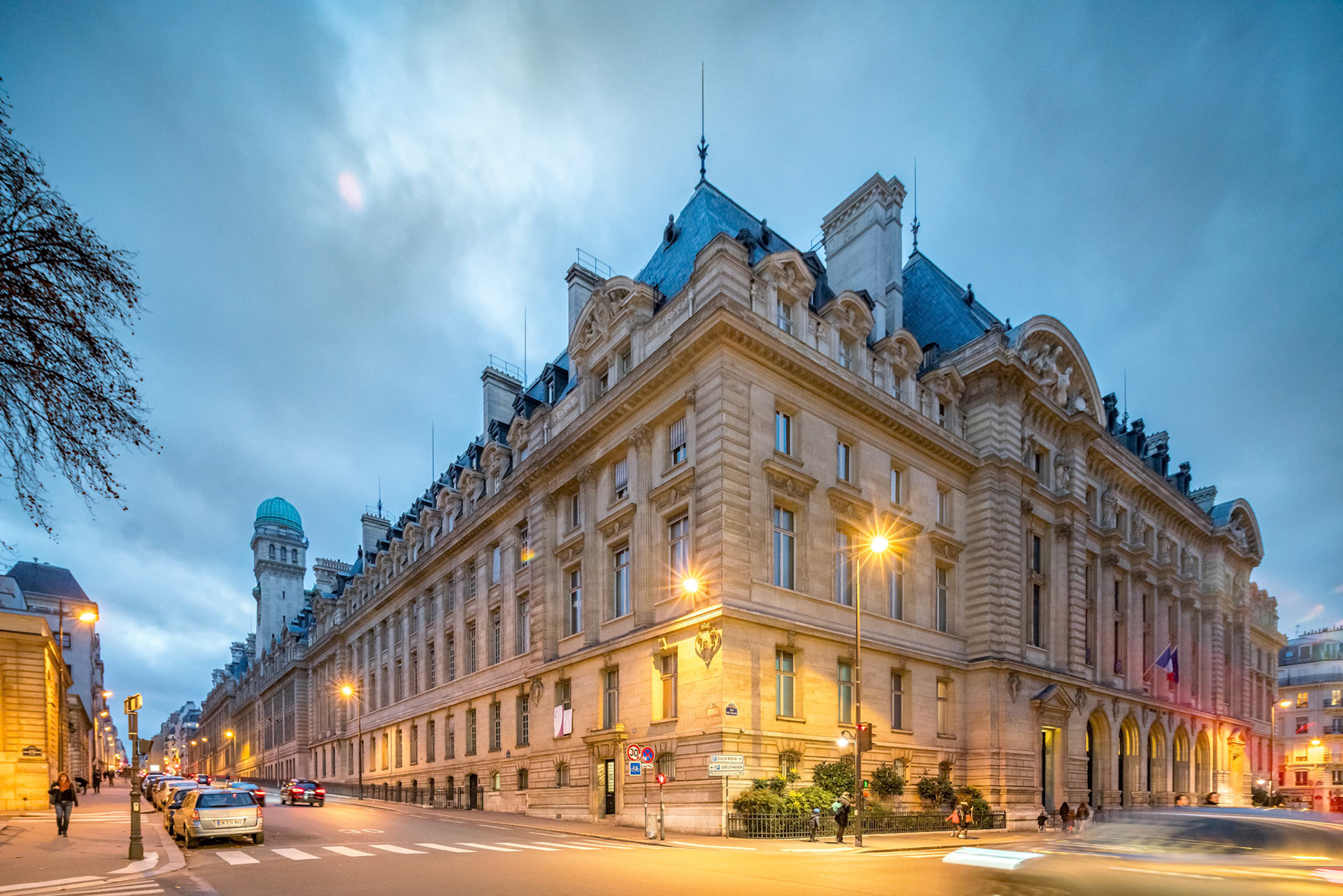 Dusk settles over the Sorbonne Faculty of Arts in Paris, streetlights aglow.