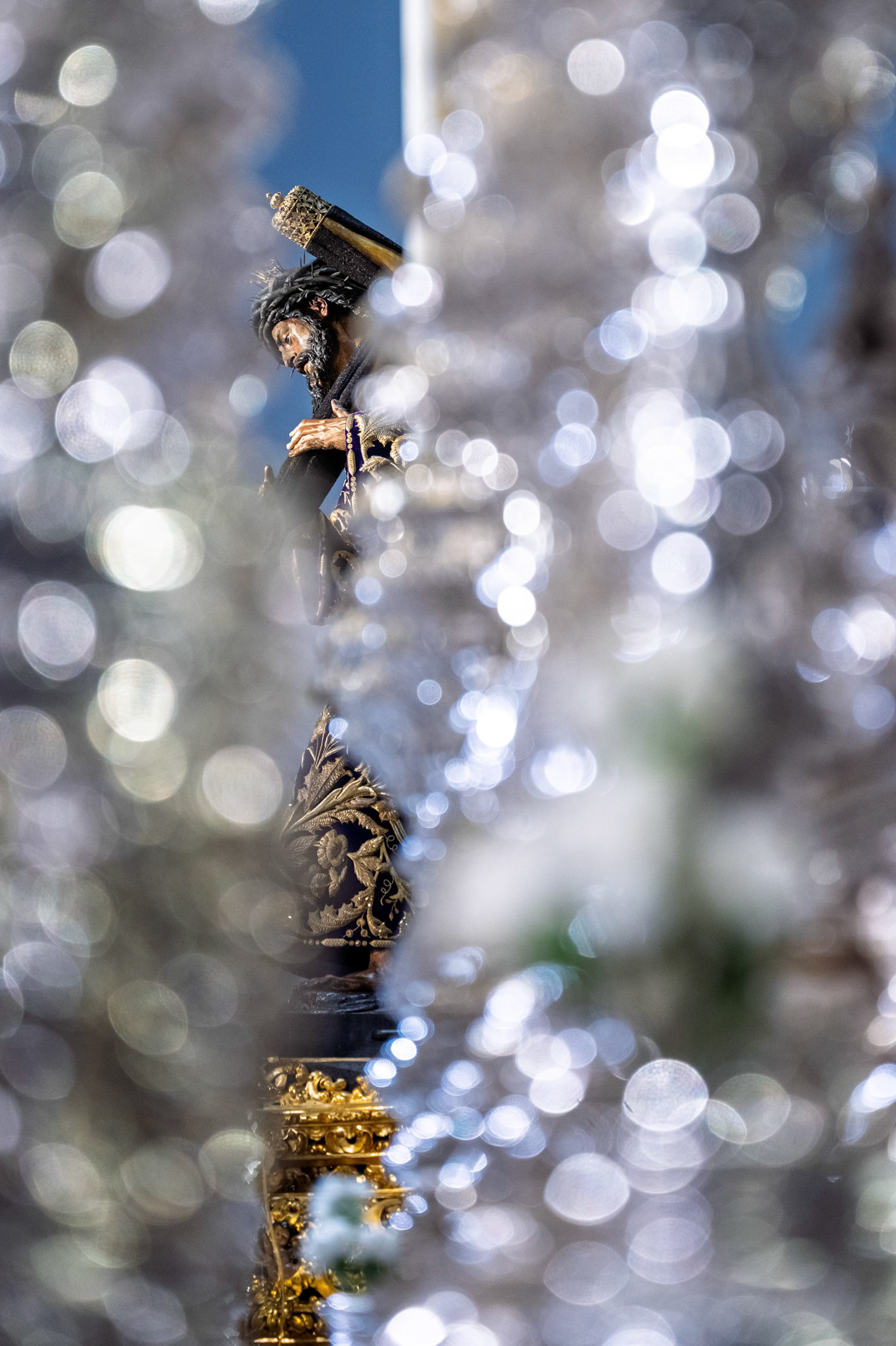 The Lord of Gran Poder, glimpsed through the silver canopy poles of the Brotherhood's palio float,