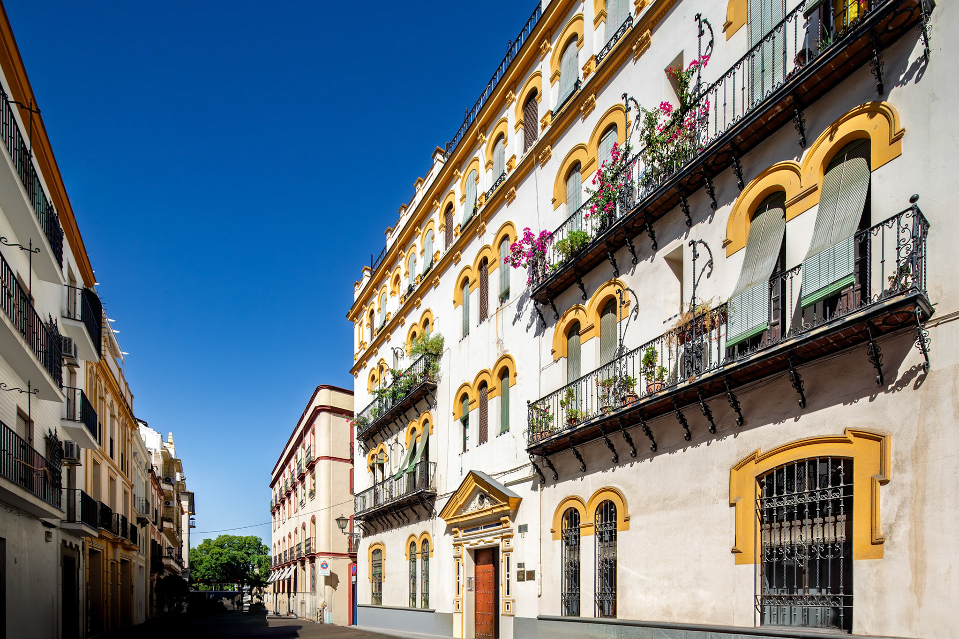 Colorful regionalist architecture stands proud on Antonia Diaz street in the vibrant Arenal neighborhood of Seville, Andalusia.