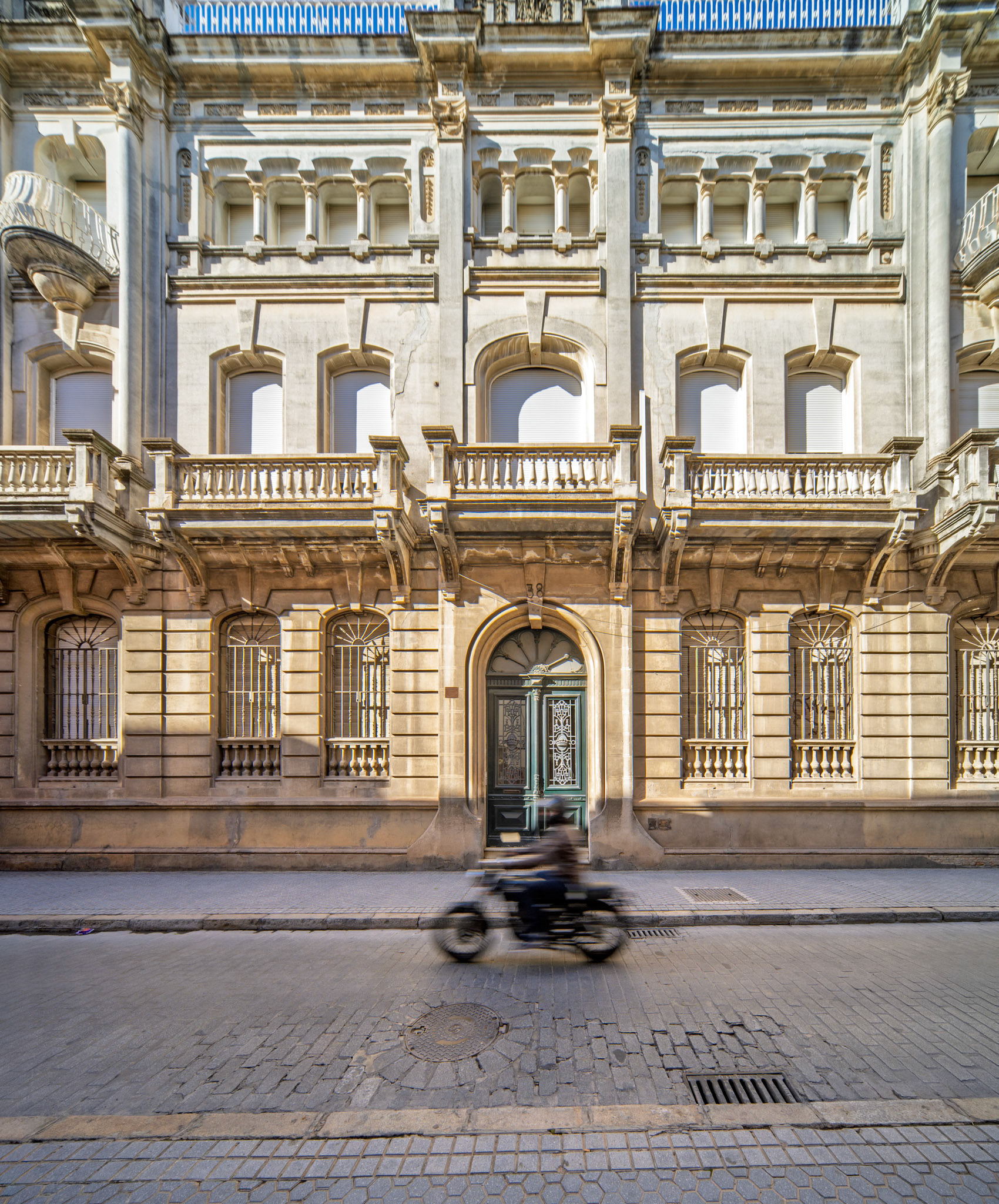 Palacio para la Marquesa de las Cuevas del Becerro, Seville—eclectic façade from 1915 blends classical symmetry with Art Nouveau flourishes, framed by motion on cobbled streets