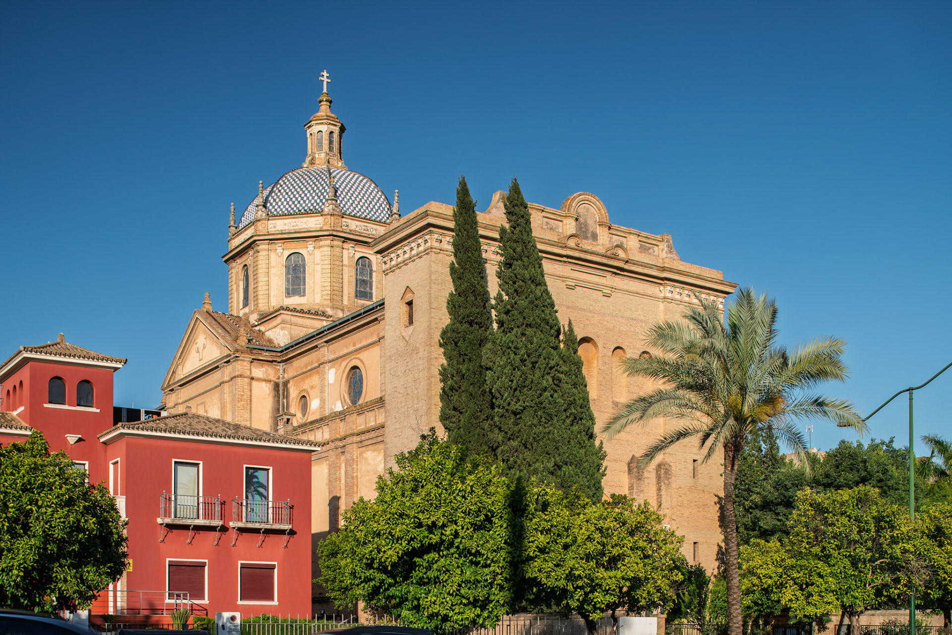 Corpus Christi Church in Seville features stunning neoclassical architecture surrounded by lush greenery, highlighting its history.