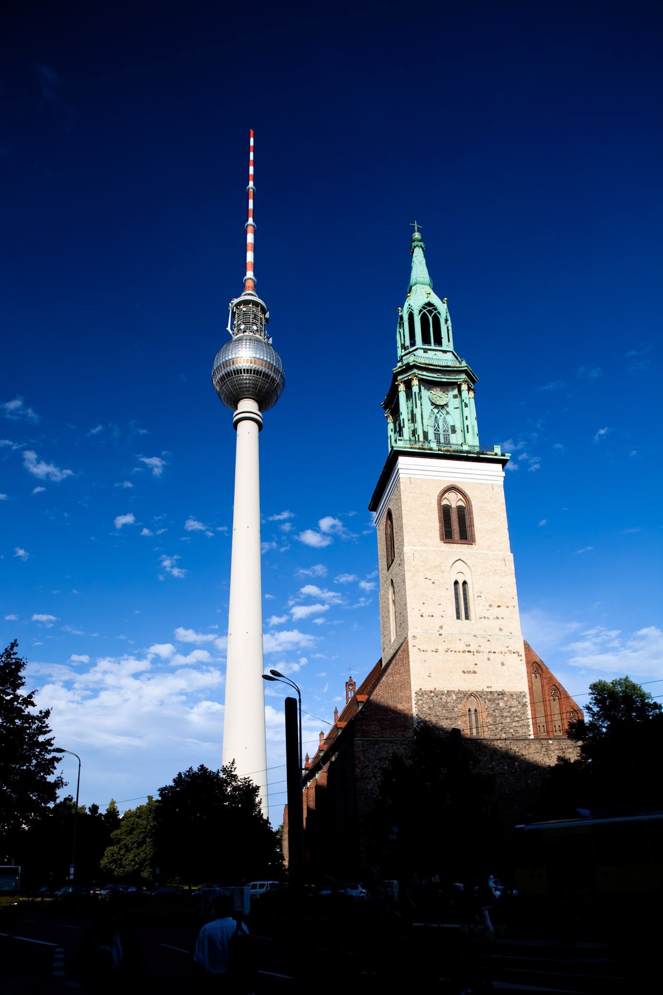 The Fernsehturm stands tall beside the historic Marienkirche in Berlin, showcasing the city\'s blend of modernity and tradition.