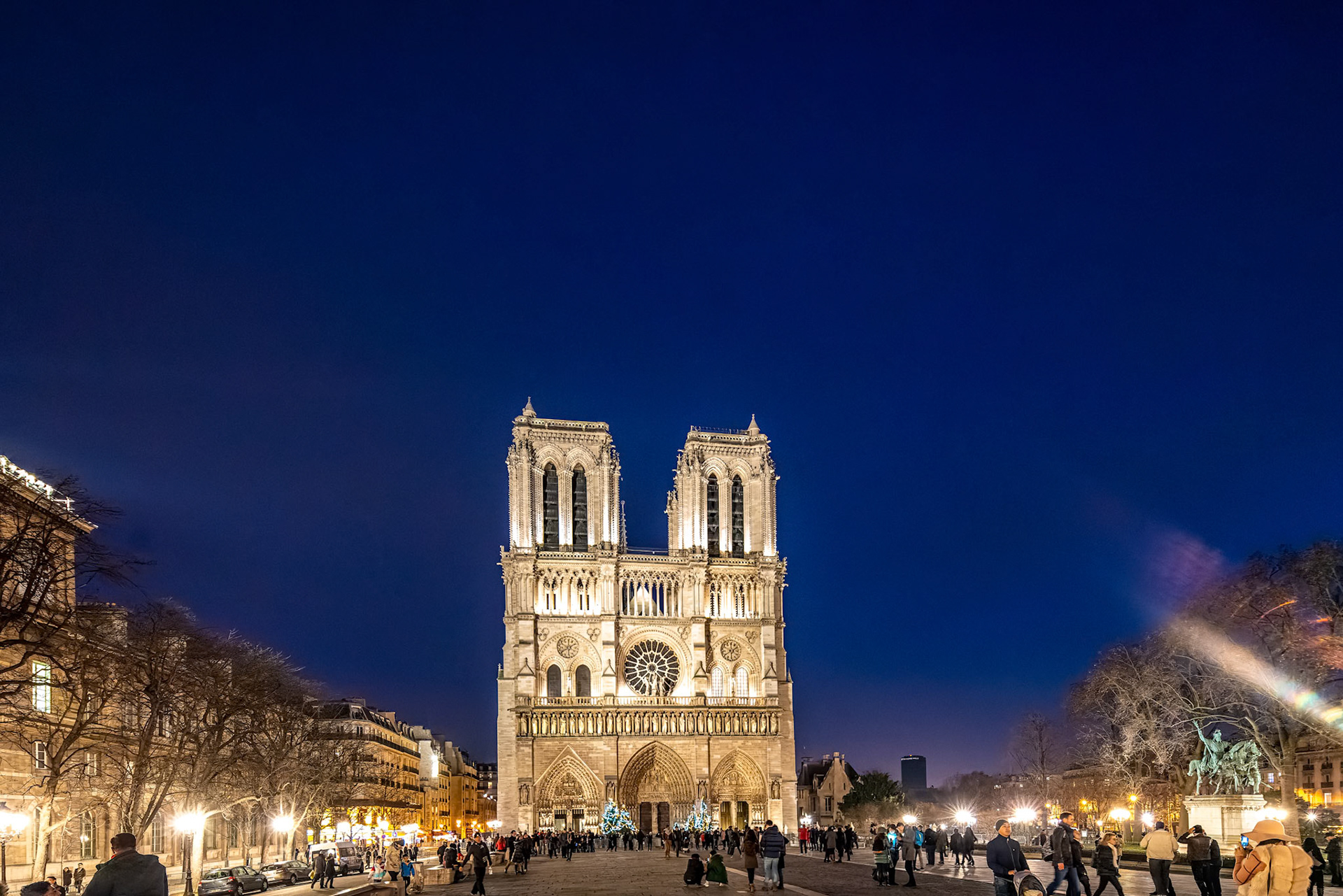 Crowd in front of iconic Notre Dame Cathedral during Christmas in Paris.