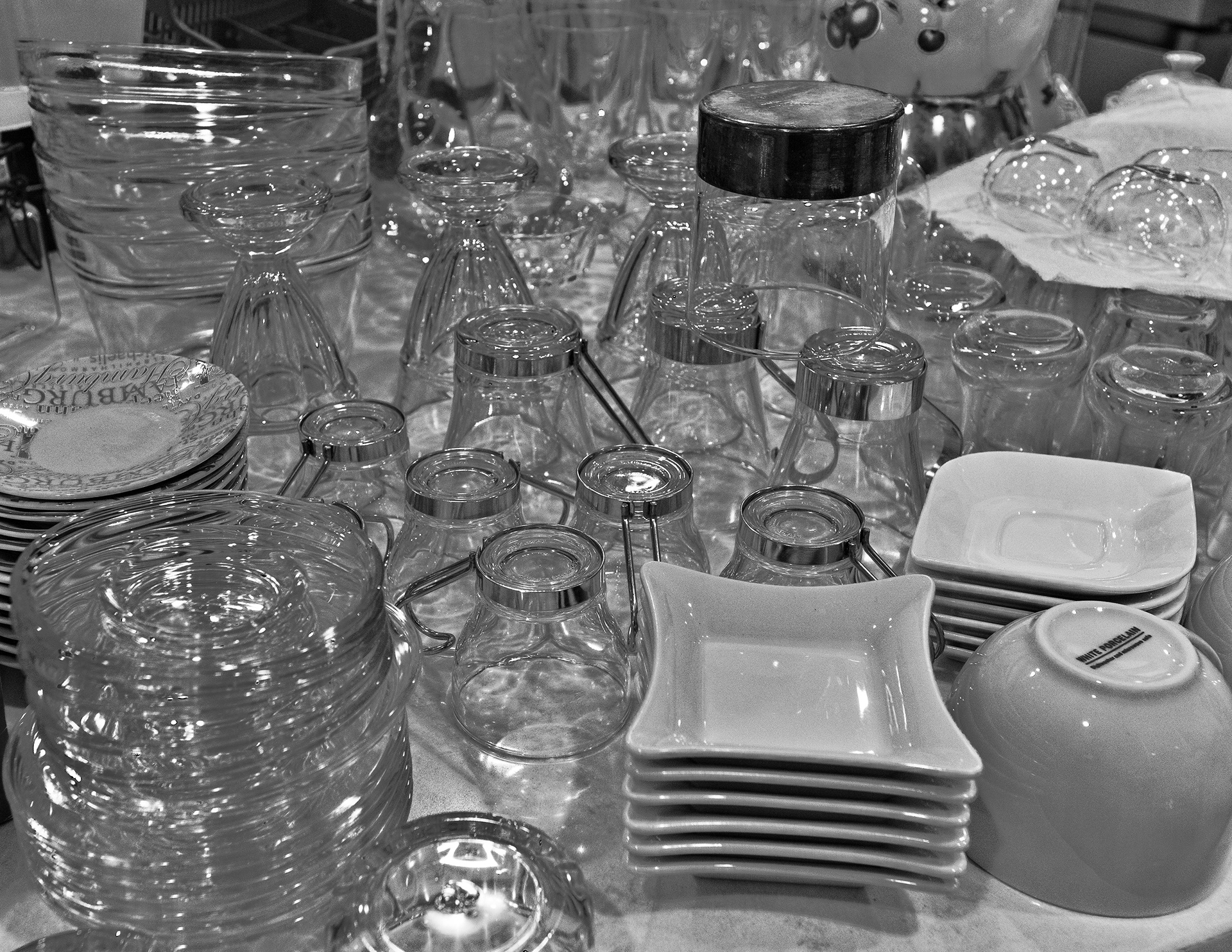 13th time I'm opening boxes and washing all kitchen stuff for disinfection. Glasses loaded the kitchen counter at the scene. They are in the still image waiting to be fit into kitchen cupboards. It's almost nighttime, but I'm still on foot. It's glass-built chaos.