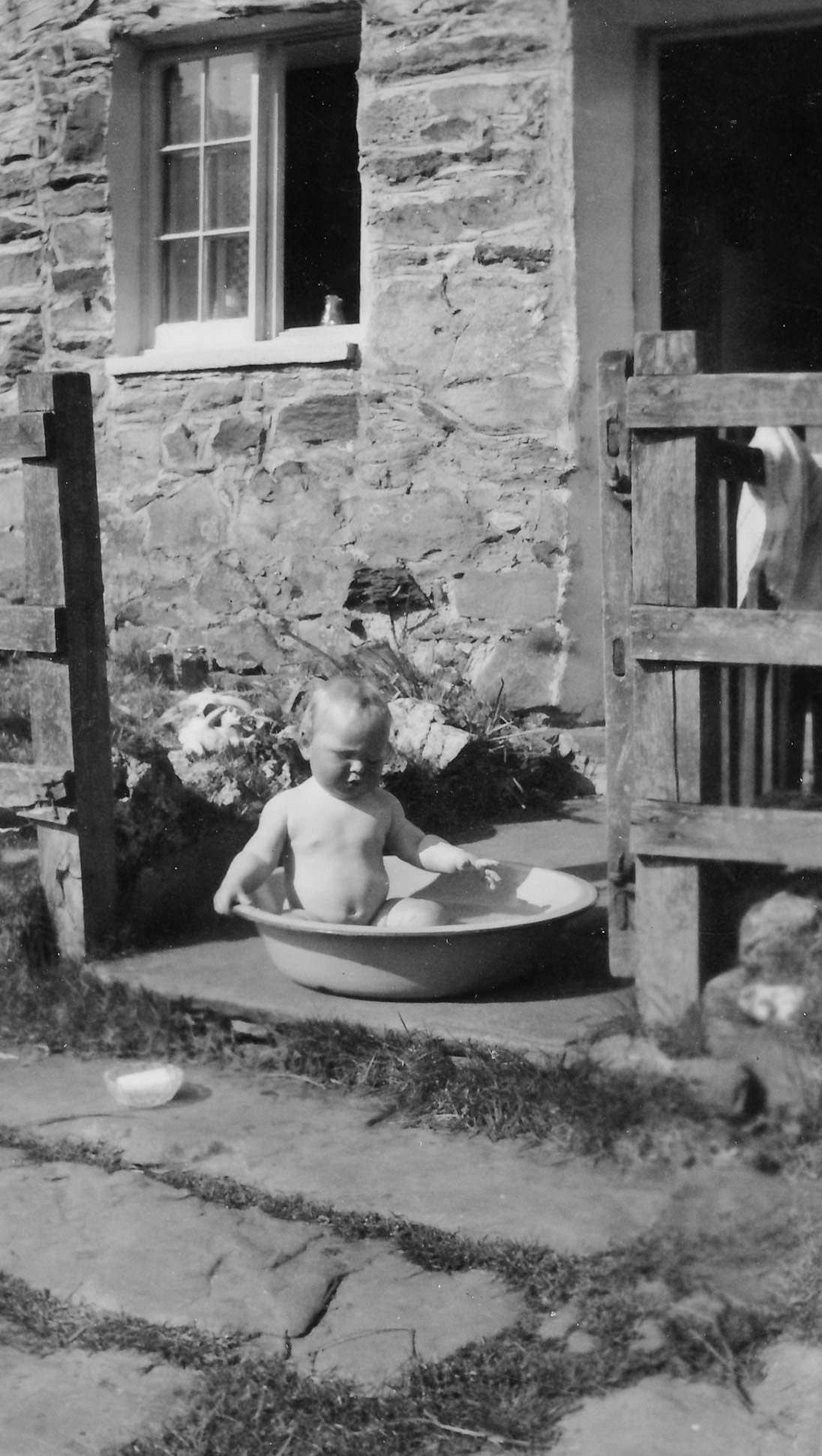 "May 1955 Nr Lake Ullswater. Howard 9 months having his daily bath in the washing up bowl"