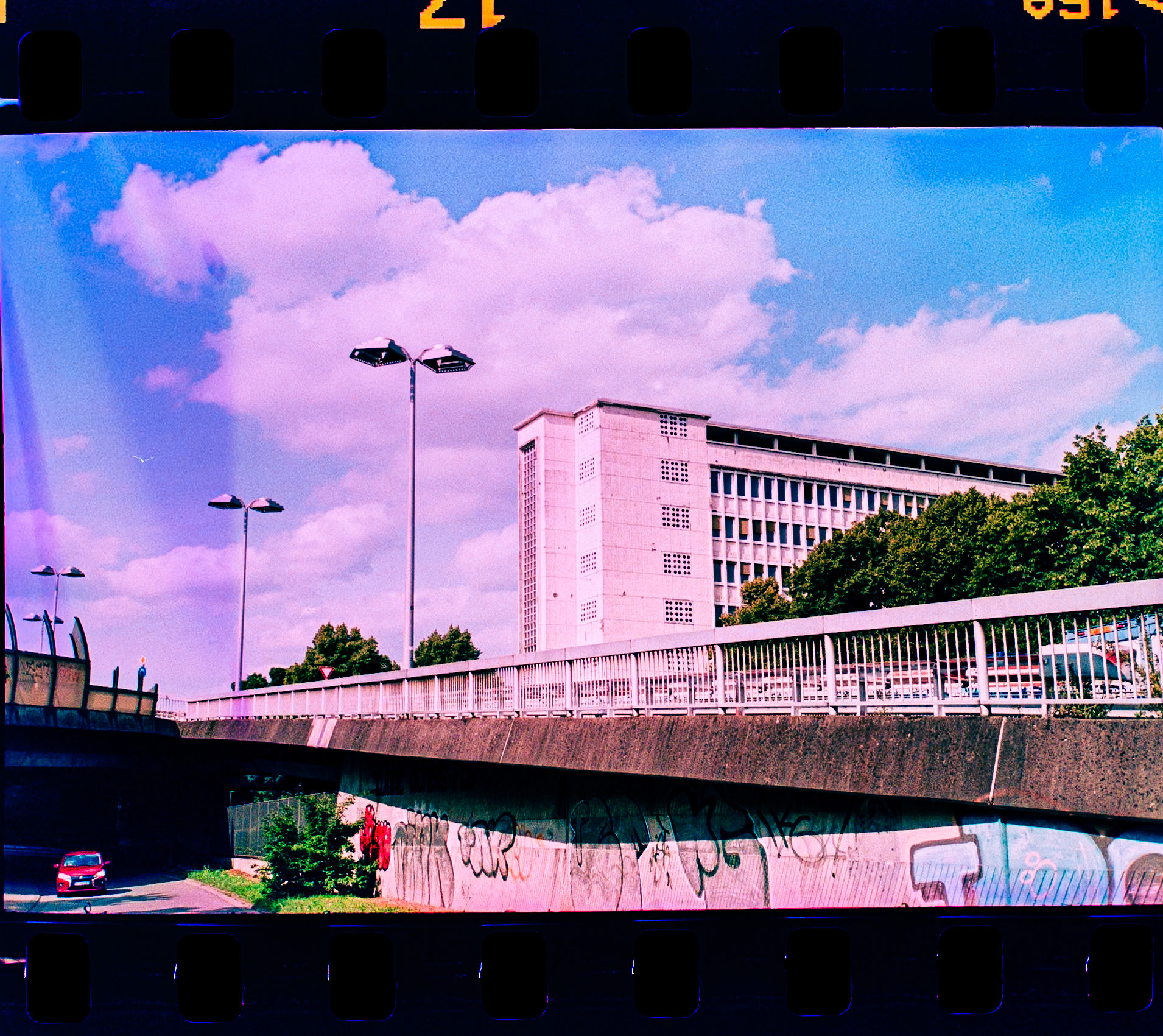 Photographed with a Rollei 35 S, featuring the legendary Sonnar 2.8/40mm lens, loaded with Agfa Precisa CT 100 — a slide film expired by 5 years. The film was cross-processed in C-41 chemistry, resulting in the signature high-contrast, color-shifted tones that define the X-Pro aesthetic.This image captures the Pingusson Building in Saarbrücken, a striking example of post-war modernist architecture, under surreal skies. The expired emulsion added unpredictable magenta and cyan shifts that contrast sharply with the rigid geometry of the facade.The film was self-developed using the Adox C-41 kit, and the negatives were digitized by photographing them with a Pentax KP and SMC Macro Limited 28mm lens setup. The analog workflow – from camera to chemicals to scan – reflects the raw and experimental character of cross-processed film.