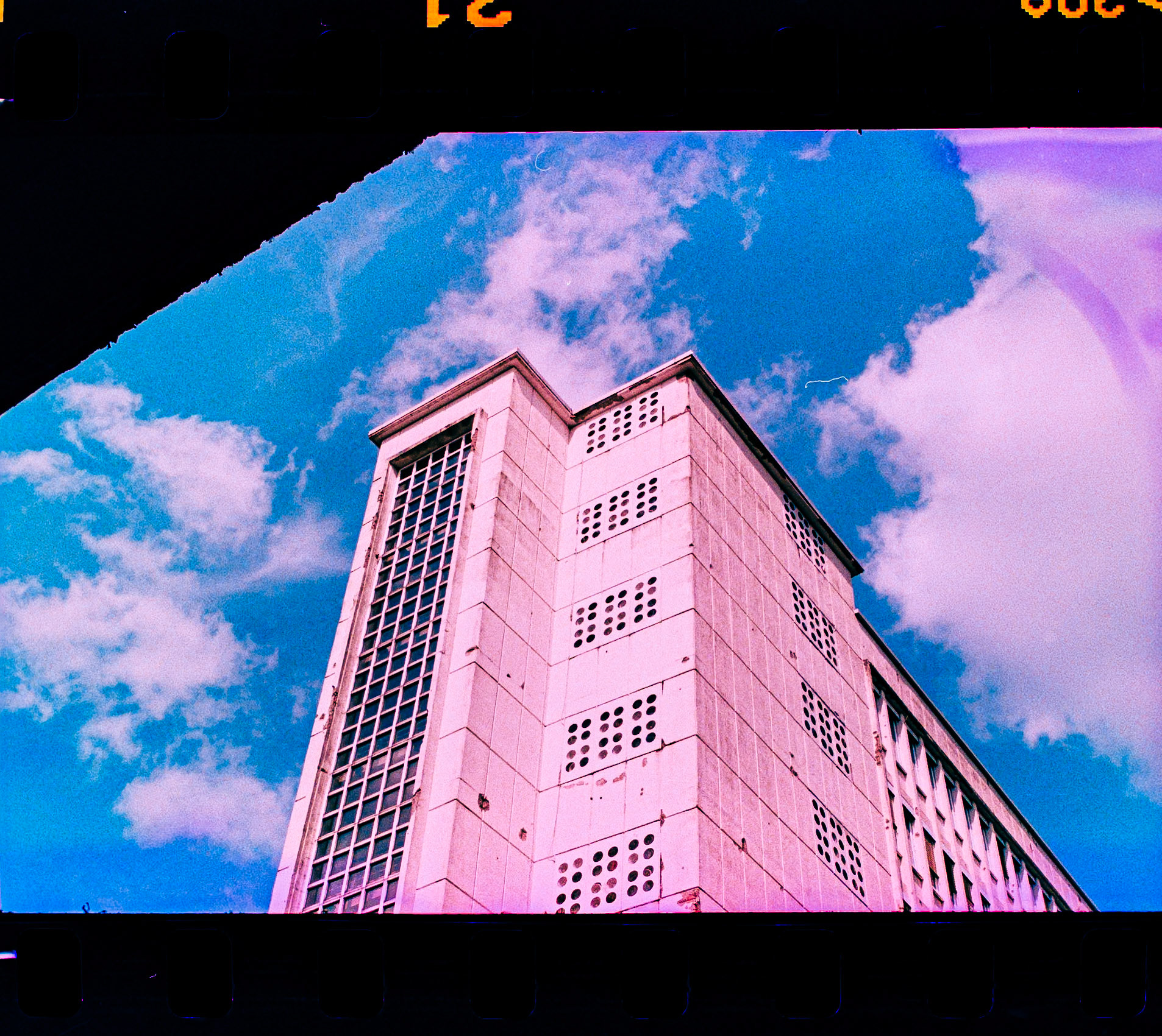 Photographed with a Rollei 35 S, featuring the legendary Sonnar 2.8/40mm lens, loaded with Agfa Precisa CT 100 — a slide film expired by 5 years. The film was cross-processed in C-41 chemistry, resulting in the signature high-contrast, color-shifted tones that define the X-Pro aesthetic.This image captures the Pingusson Building in Saarbrücken, a striking example of post-war modernist architecture, under surreal skies. The expired emulsion added unpredictable magenta and cyan shifts that contrast sharply with the rigid geometry of the facade.The film was self-developed using the Adox C-41 kit, and the negatives were digitized by photographing them with a Pentax KP and SMC Macro Limited 28mm lens setup. The analog workflow – from camera to chemicals to scan – reflects the raw and experimental character of cross-processed film.