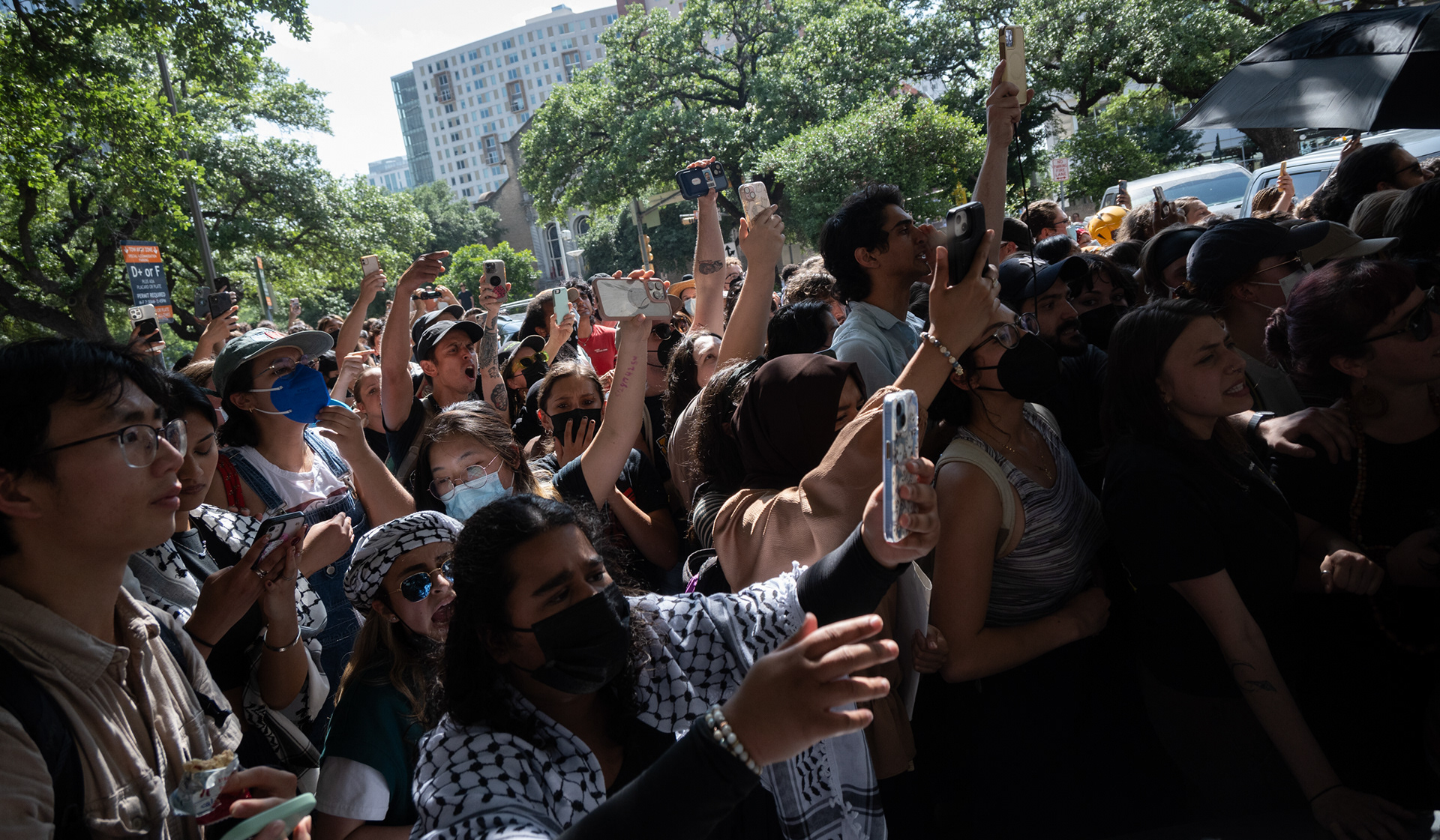 The crowd films as police push into them on 22nd Street on UT Austin's campus on April 29, 2024.