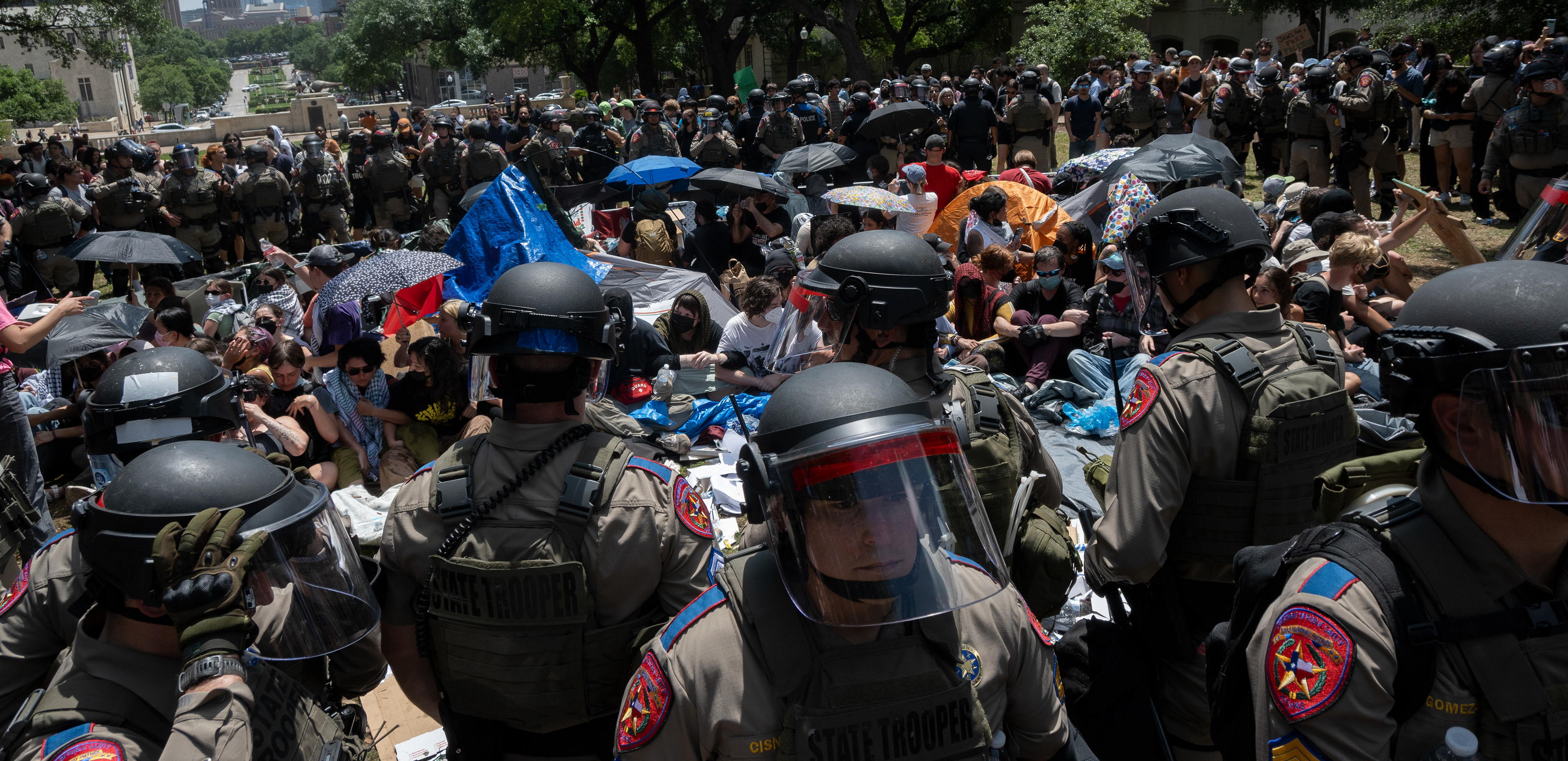 Members of the encampment on UT's South Mall lawn link arms April 29, 2024 in preparation for police force as officers make their way towards the circle.