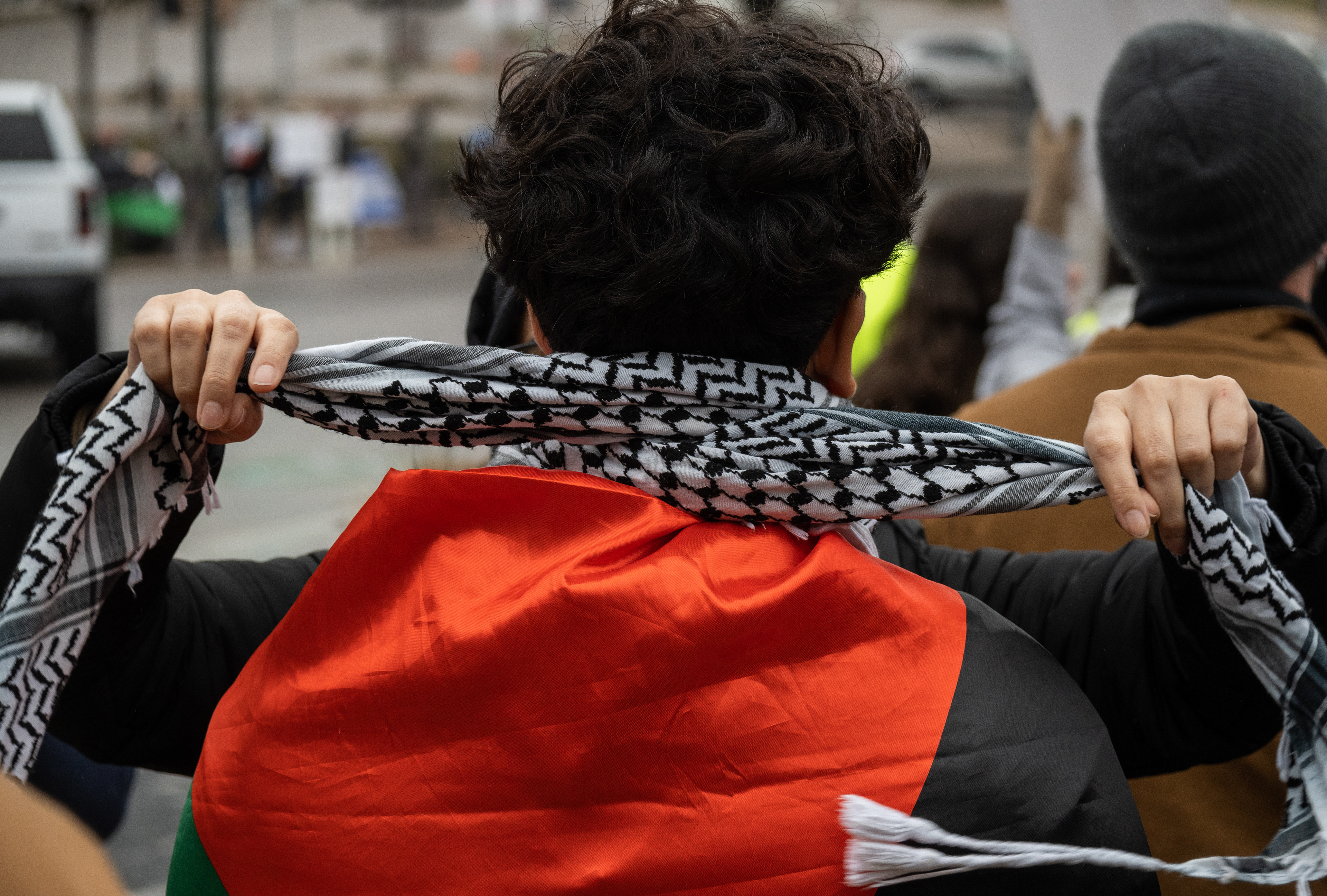 A mother wraps a Keffiyeh around her son's neck at the protest in support of Yemen and Palestine on Congress Avenue on Jan. 21, 2024.