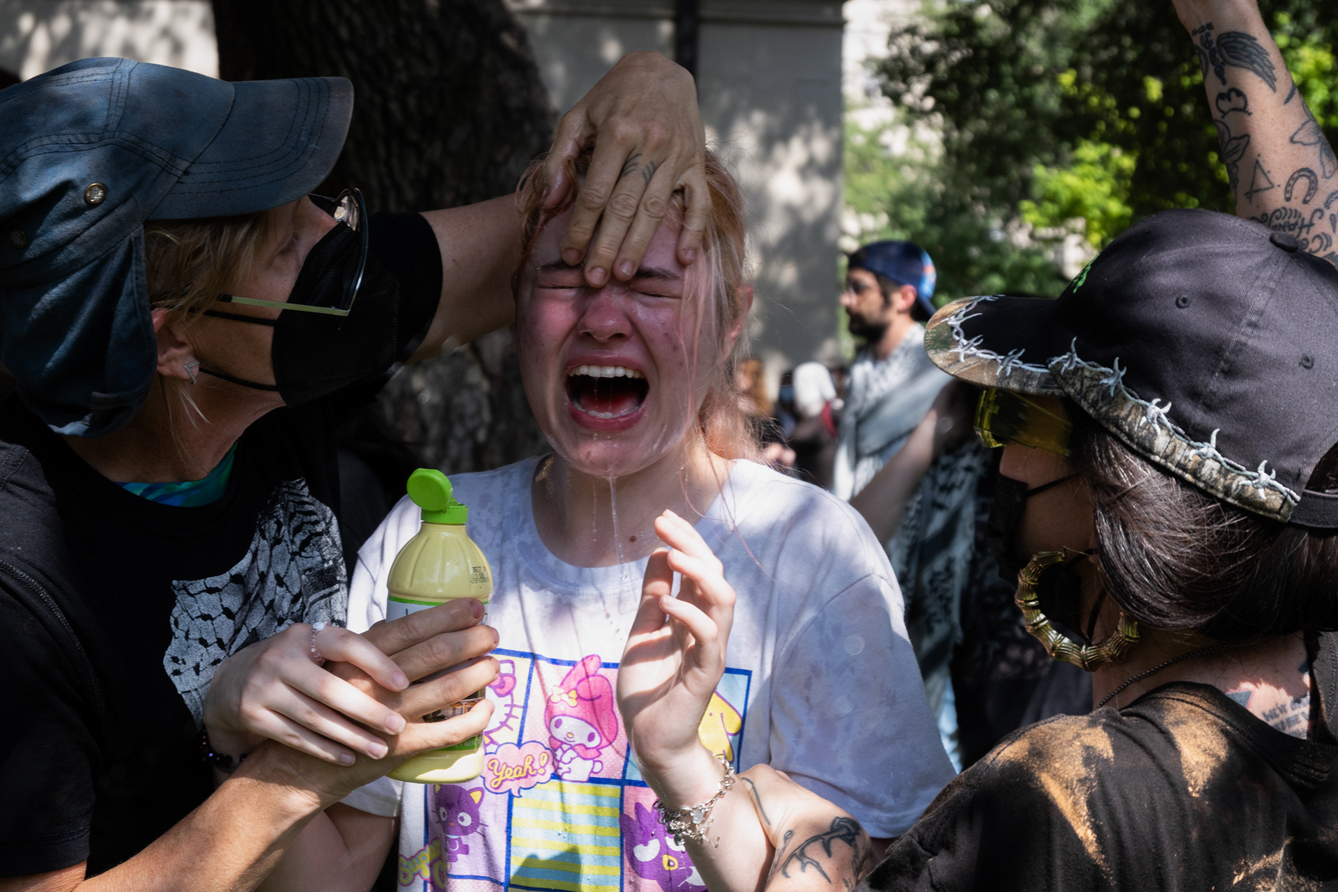 People pour water on someone's face April 29, 2024 to help relieve the pain of getting pepper sprayed on UT Austin's campus.