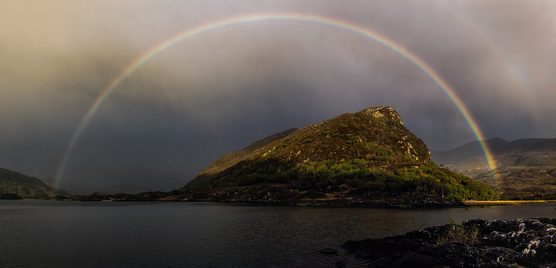 A full rainbow on a lake along the Ring of Kerry