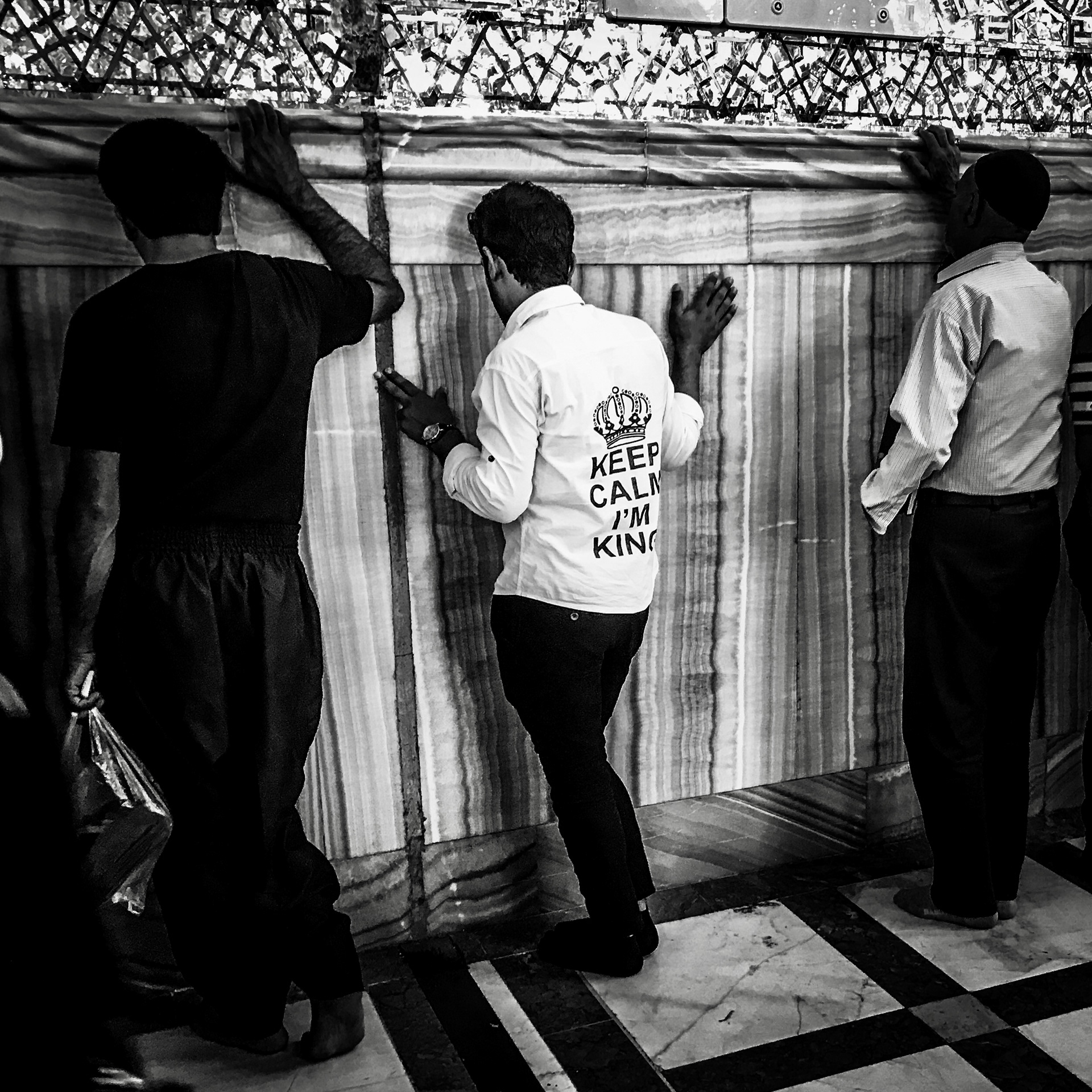 A pilgrim praying against the wall of the prophets tomb. I love his shirt, keep calm I'm King